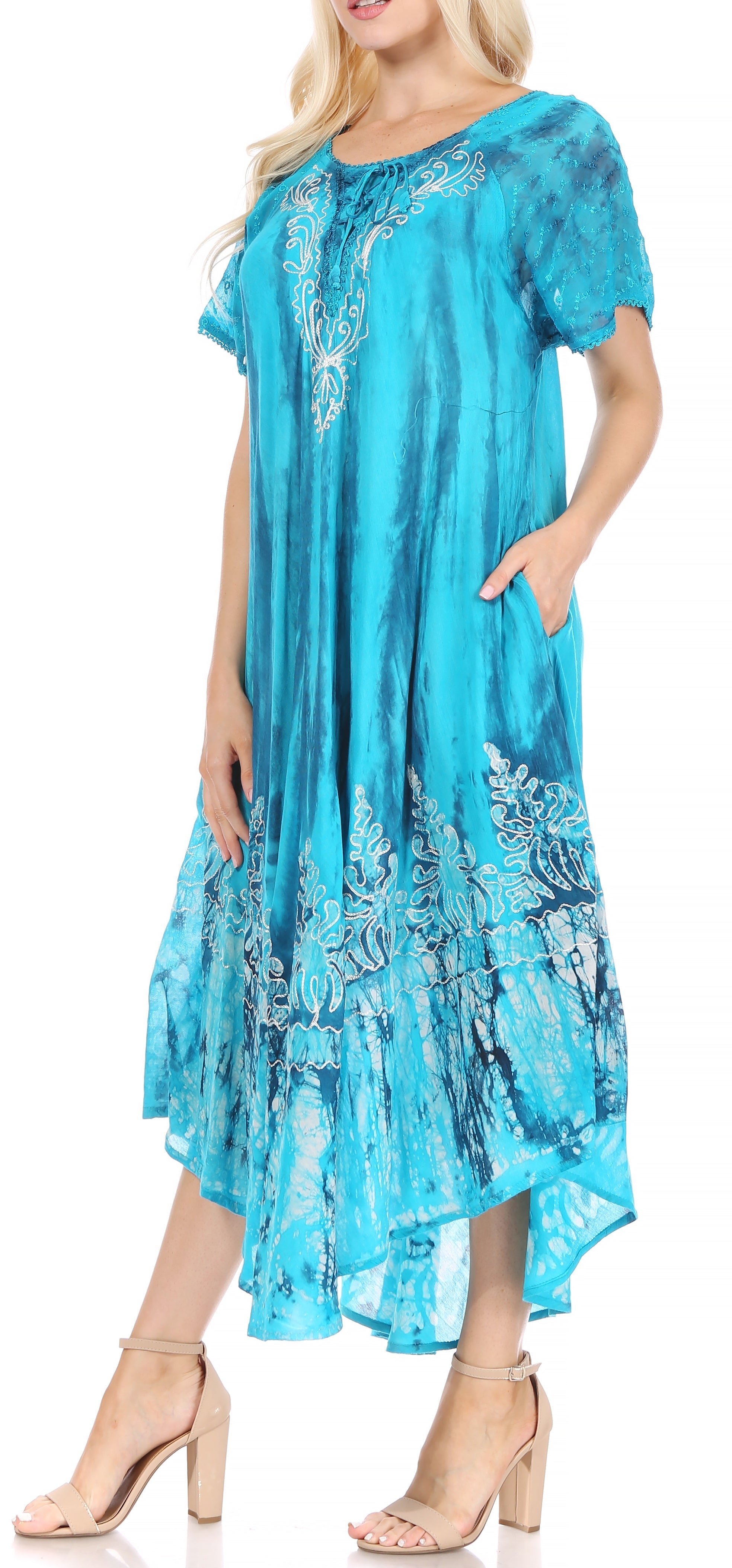 Woman wearing a blue embroidered dress with a white background