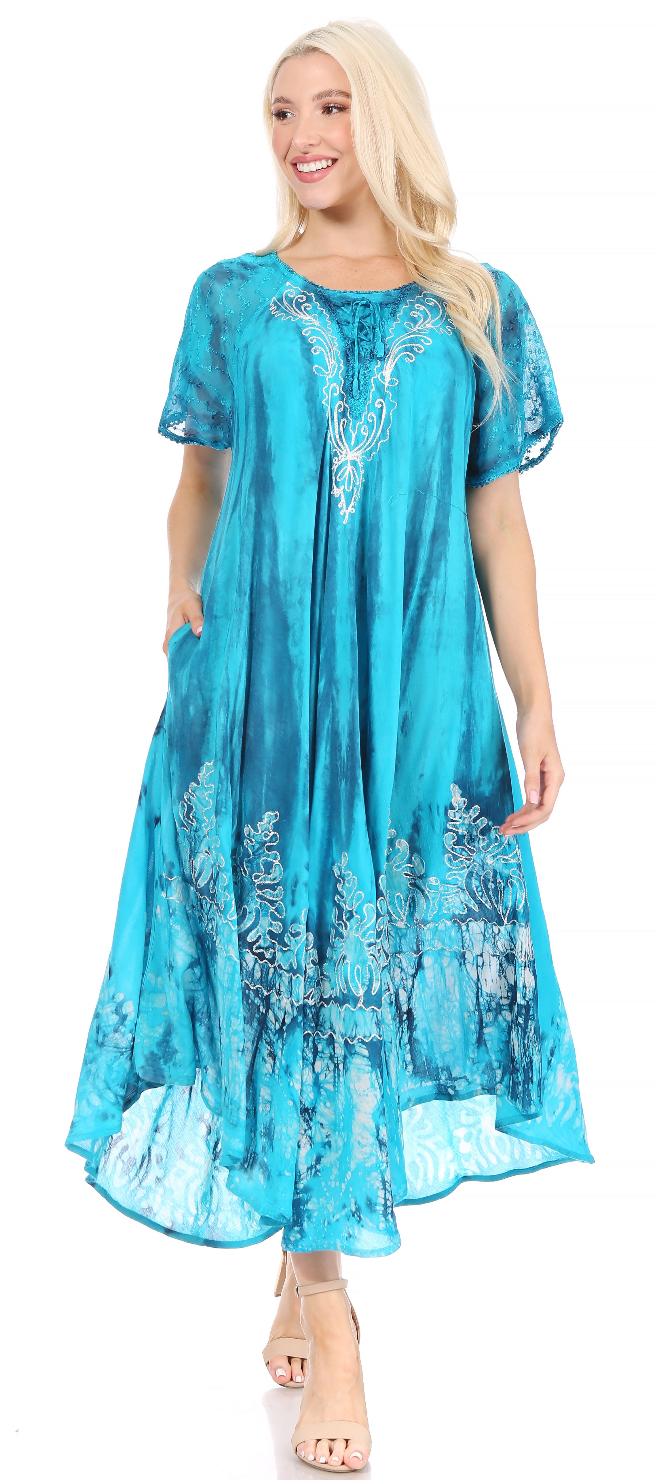 Woman wearing a turquoise dress with floral patterns on a white background