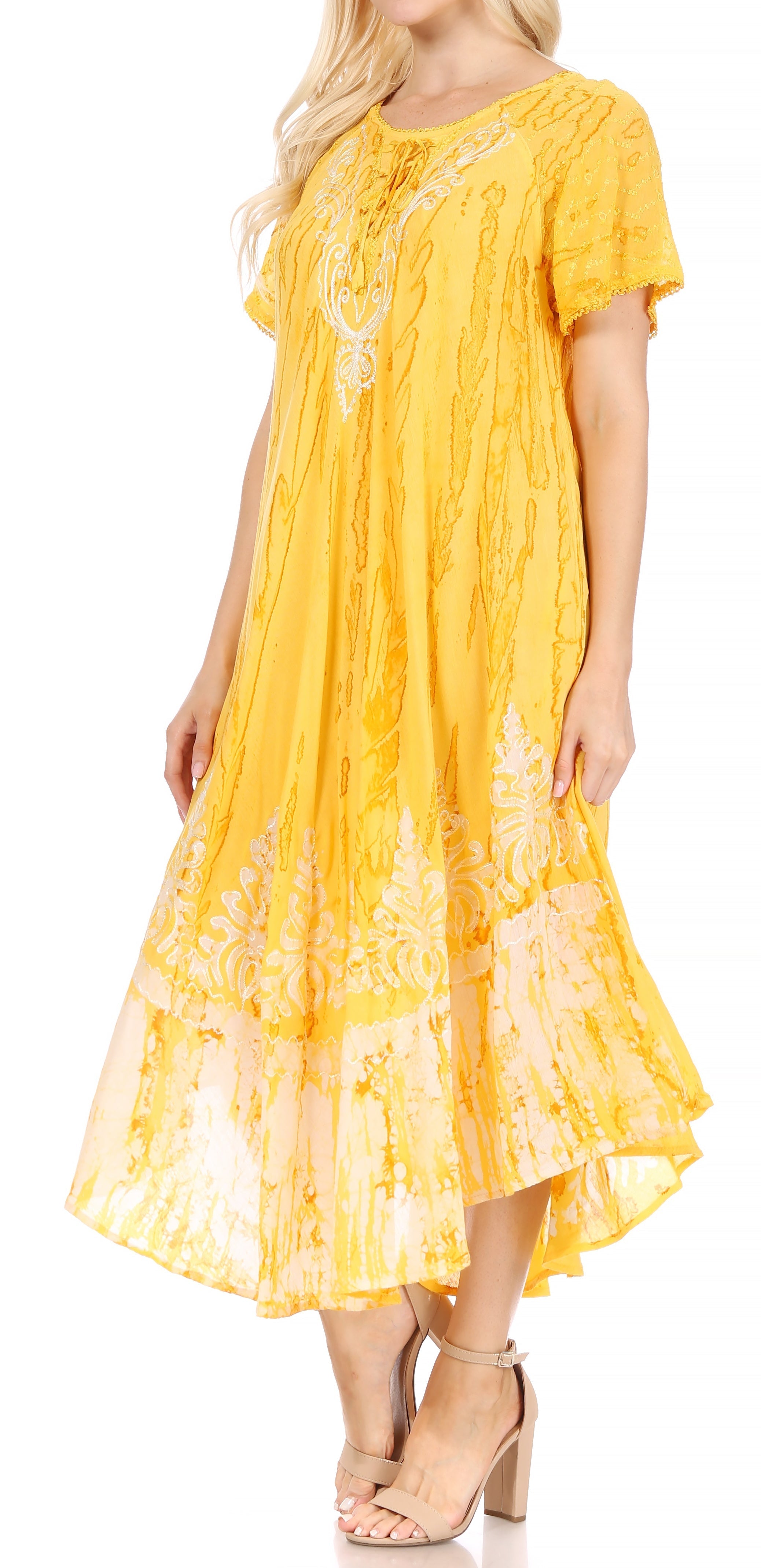 Woman wearing a yellow dress with lace details on a white background