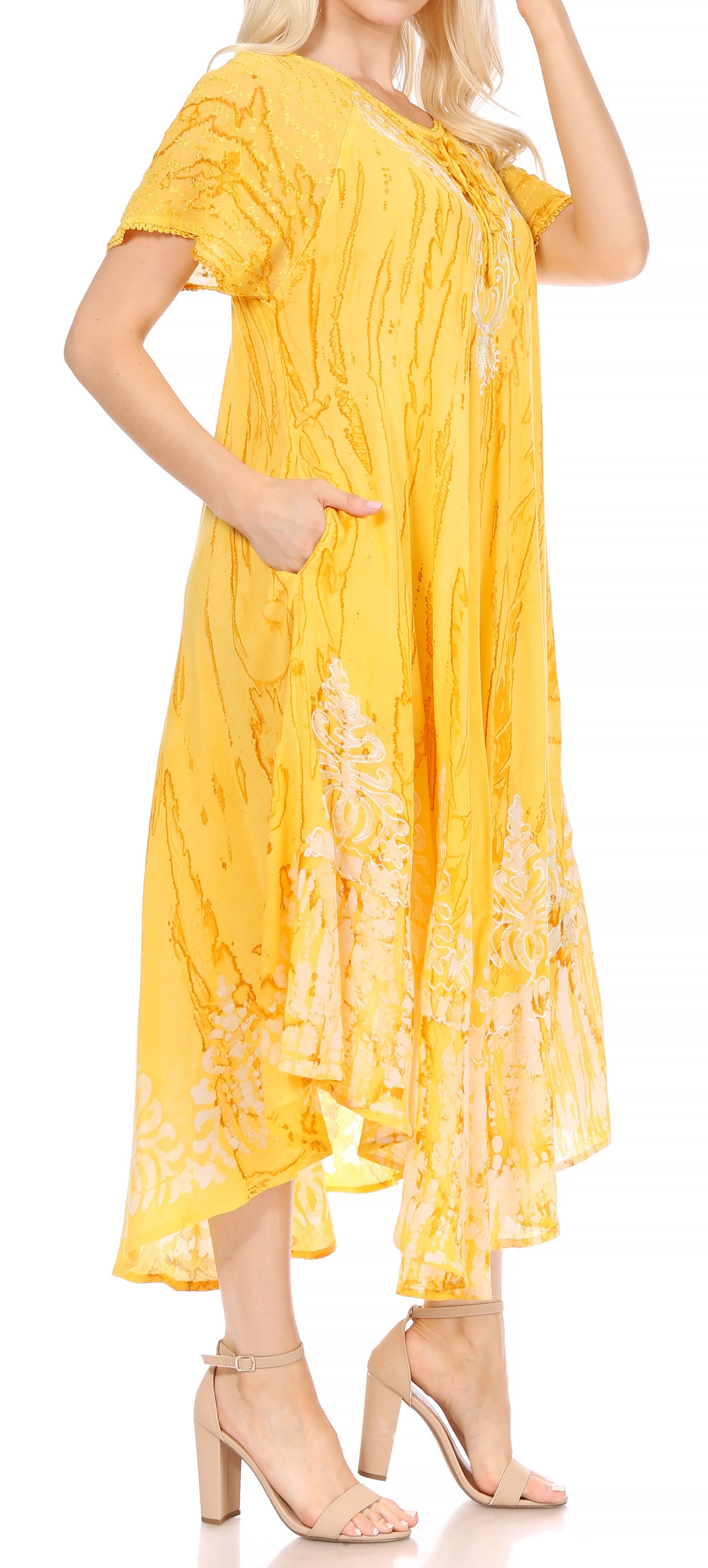 Woman wearing a yellow dress with floral patterns on a white background