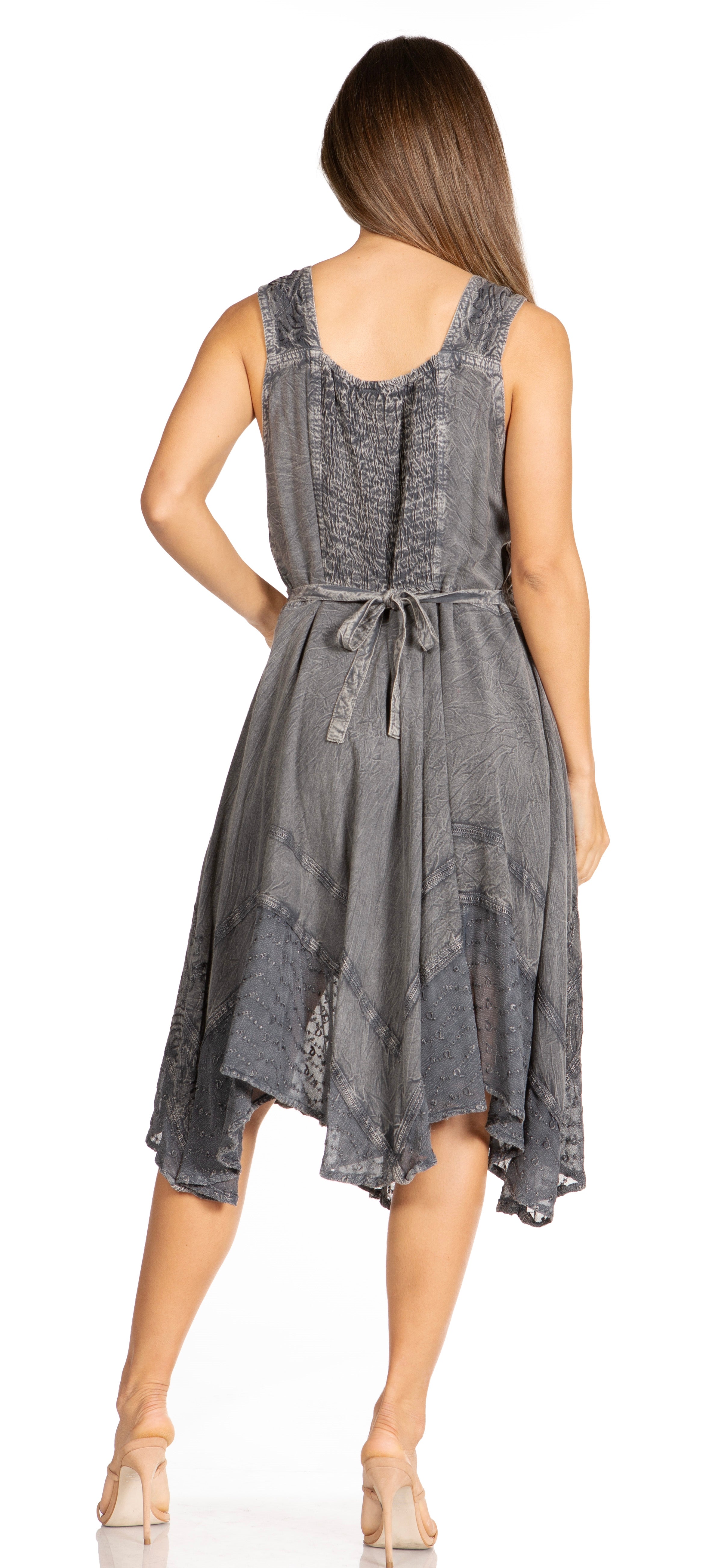 Woman wearing a sleeveless, patterned dress with a tie waist on a white background