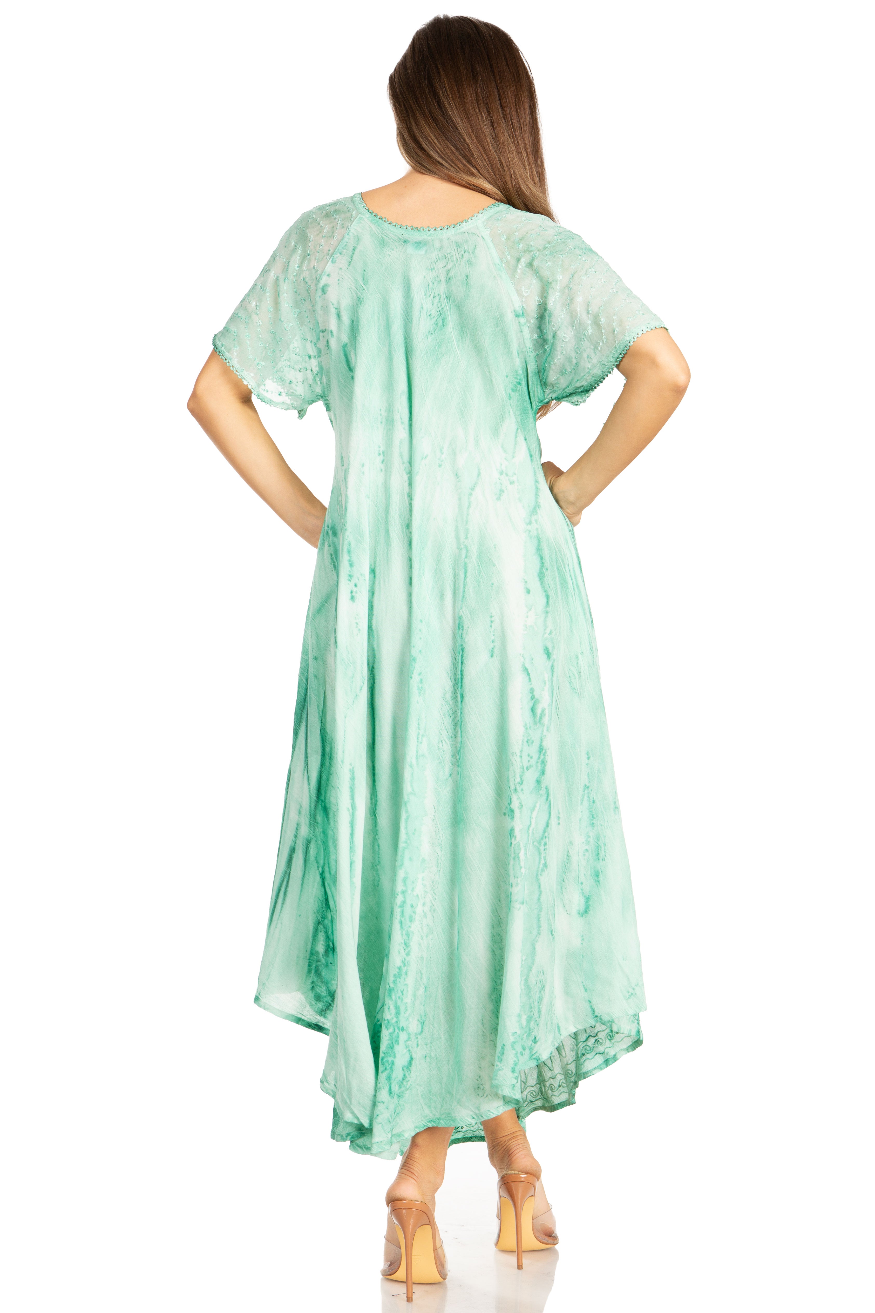 Woman wearing a light green dress with floral patterns on a white background