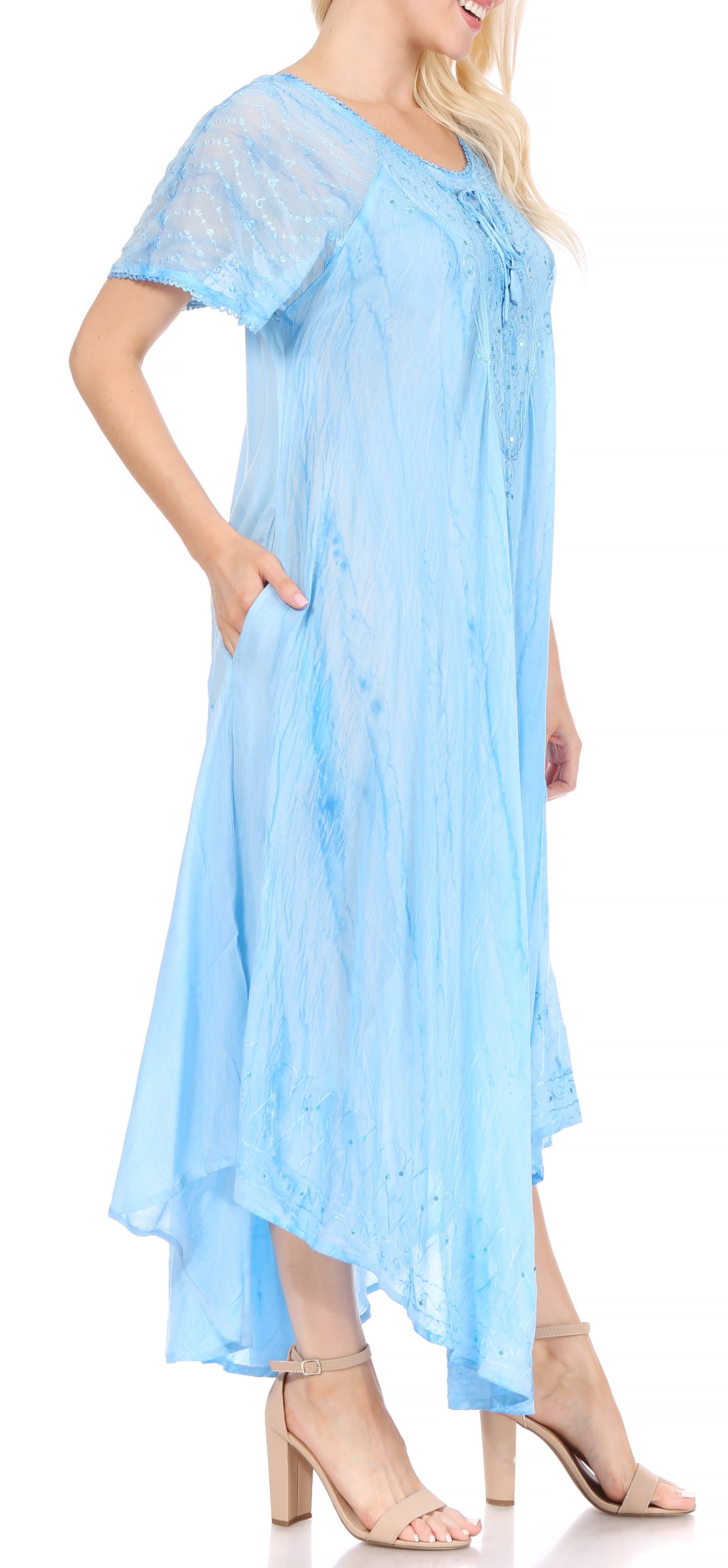 Woman wearing a light blue dress with a sheer overlay on a white background