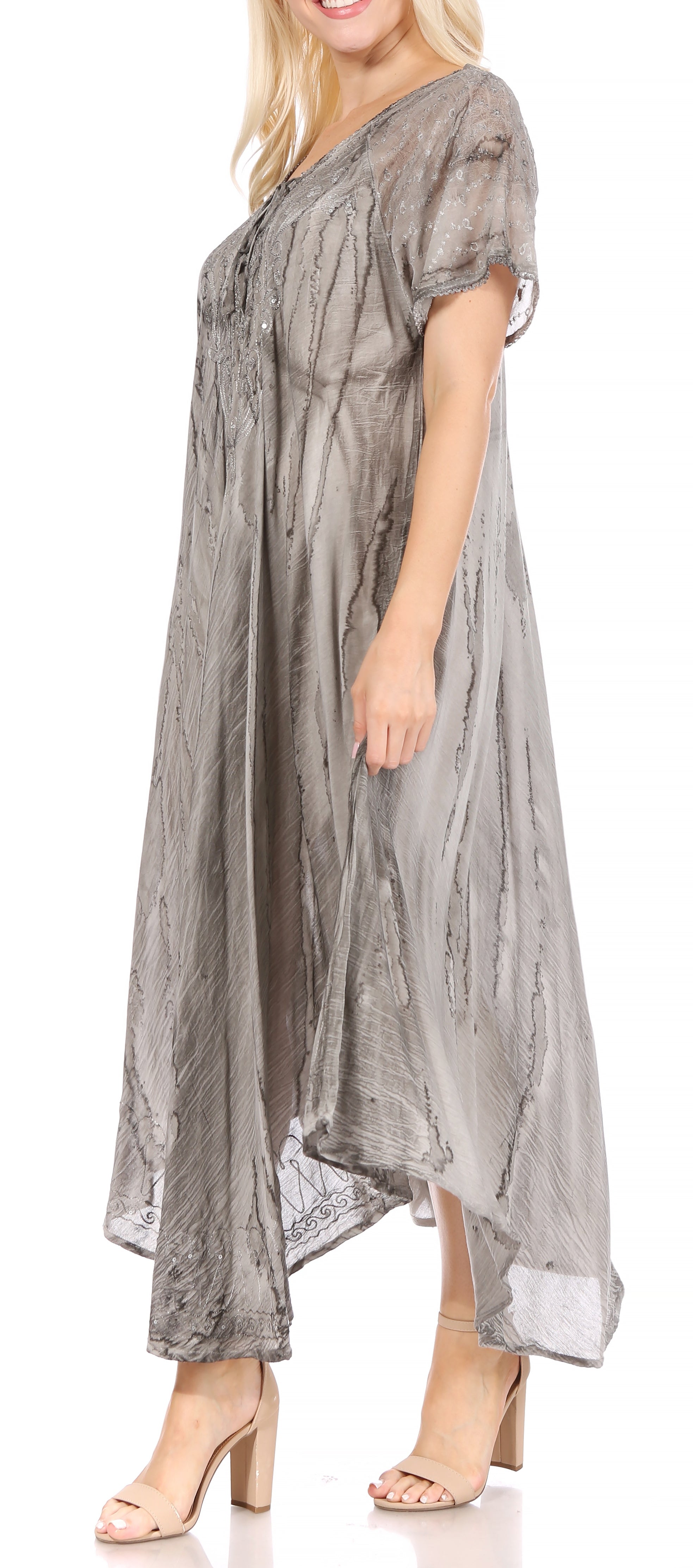 Woman wearing a long, flowing gray dress on a white background