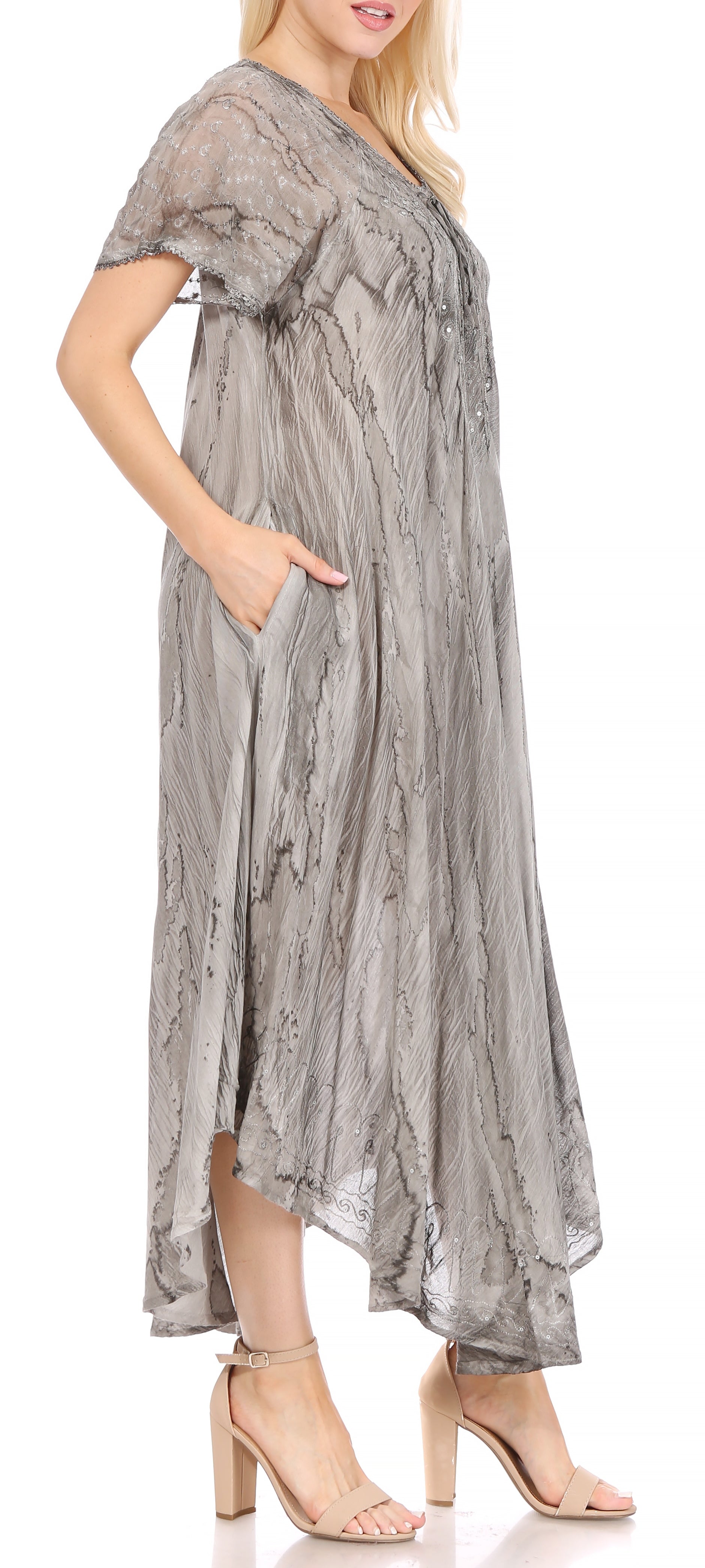 Woman wearing a long, flowing dress with a subtle pattern on a white background