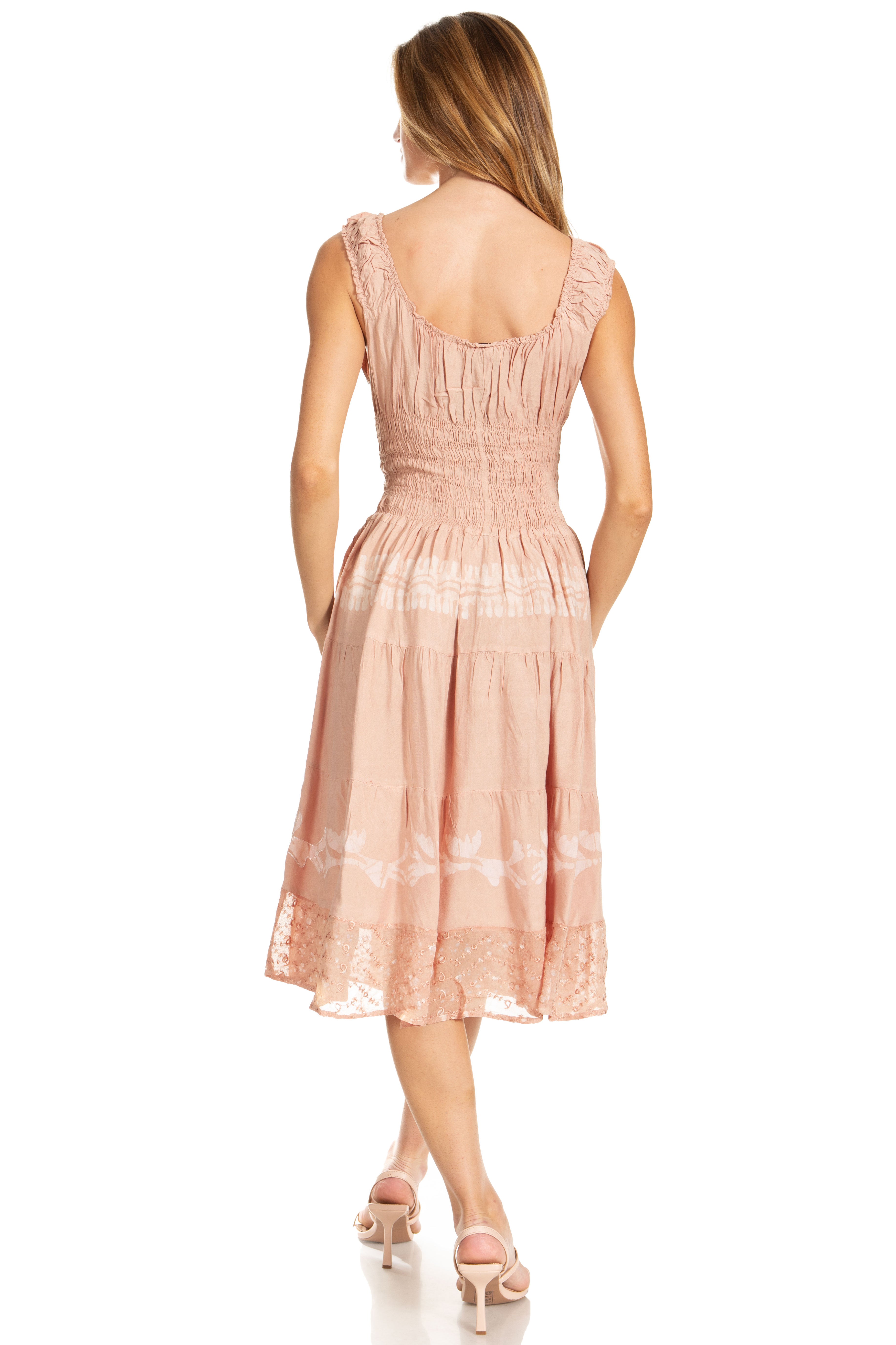 Woman wearing a pink dress with lace details on a white background