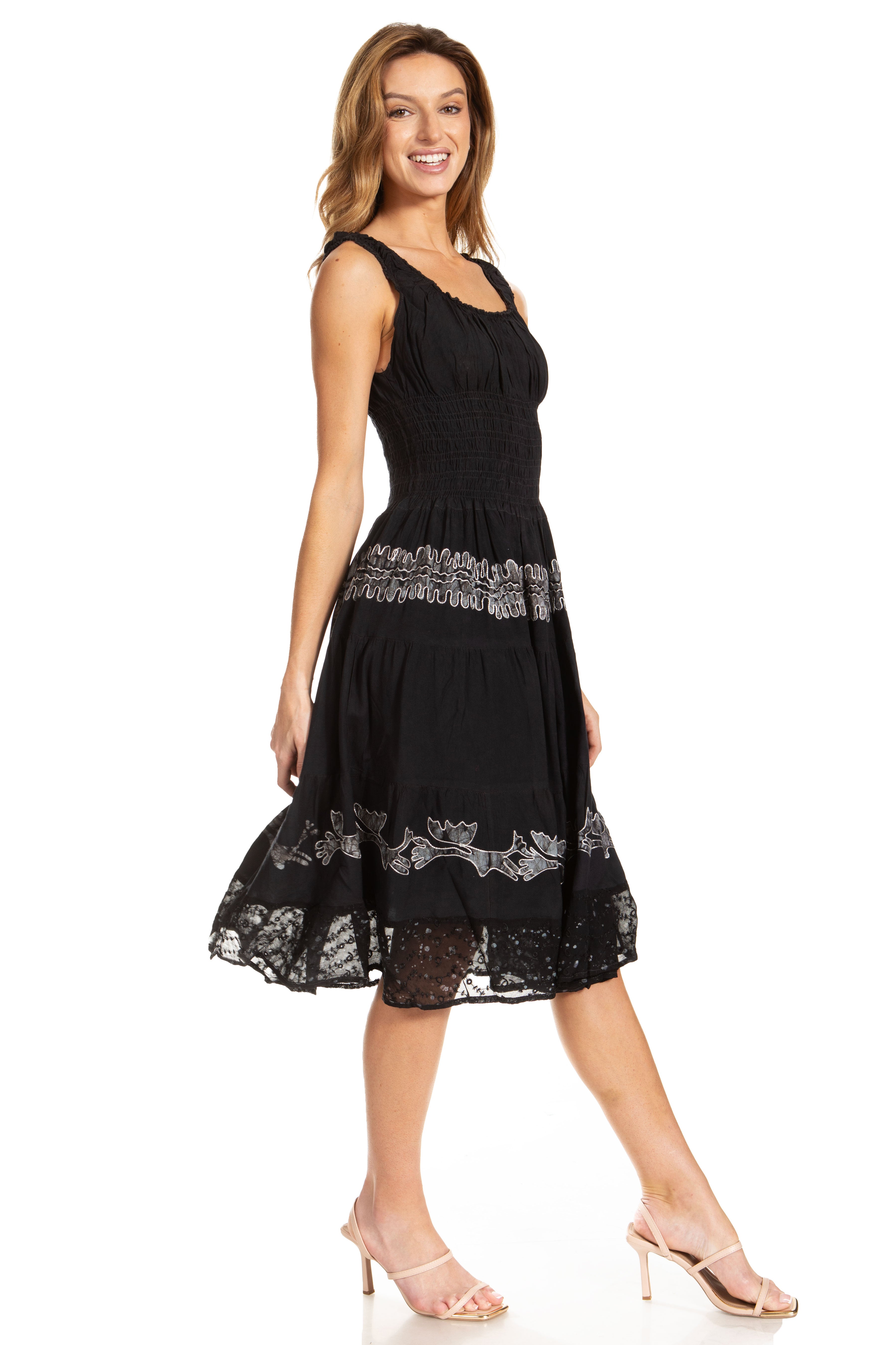 Woman wearing a black dress with lace details on a white background