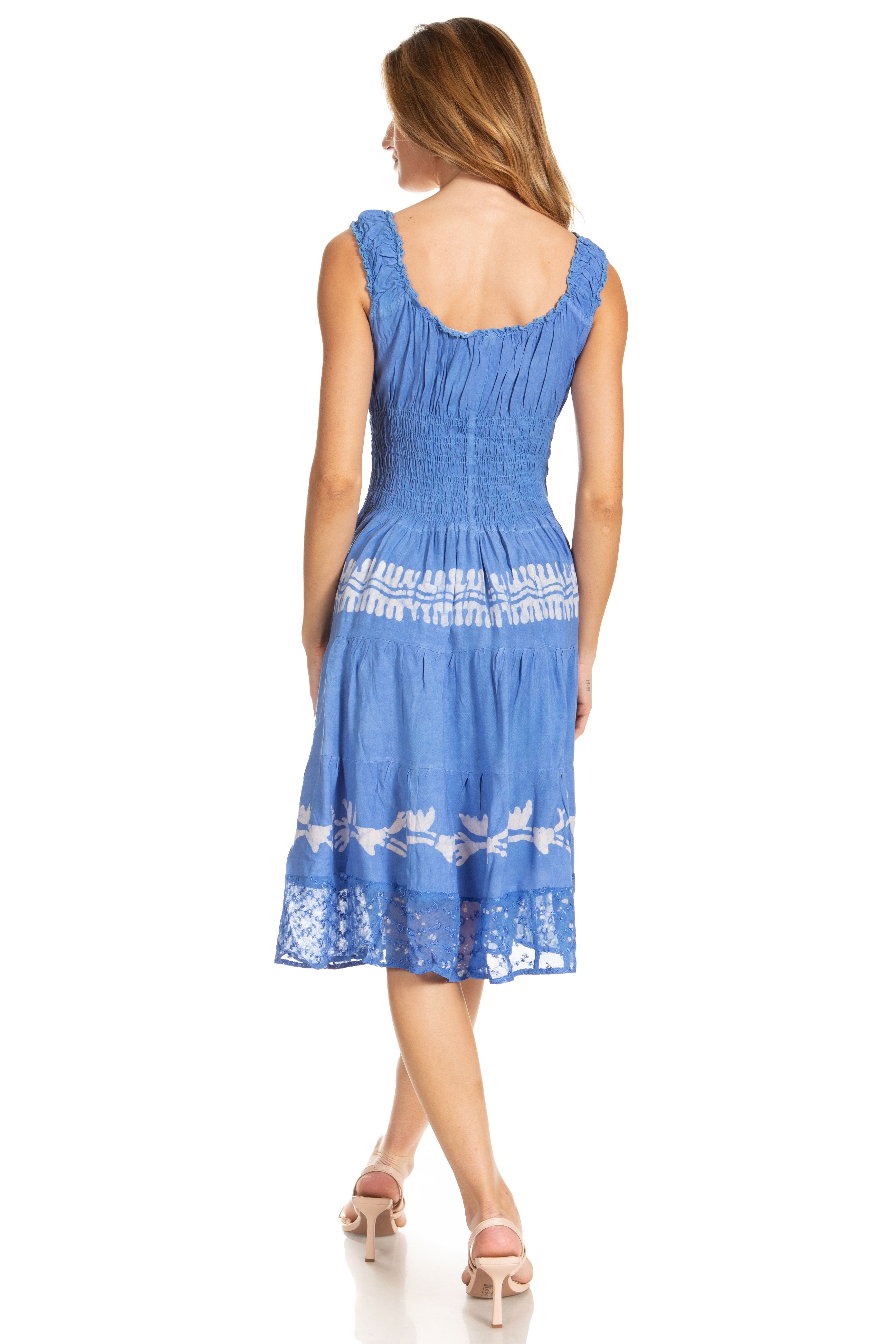 Woman wearing a blue dress with white floral embroidery on a white background