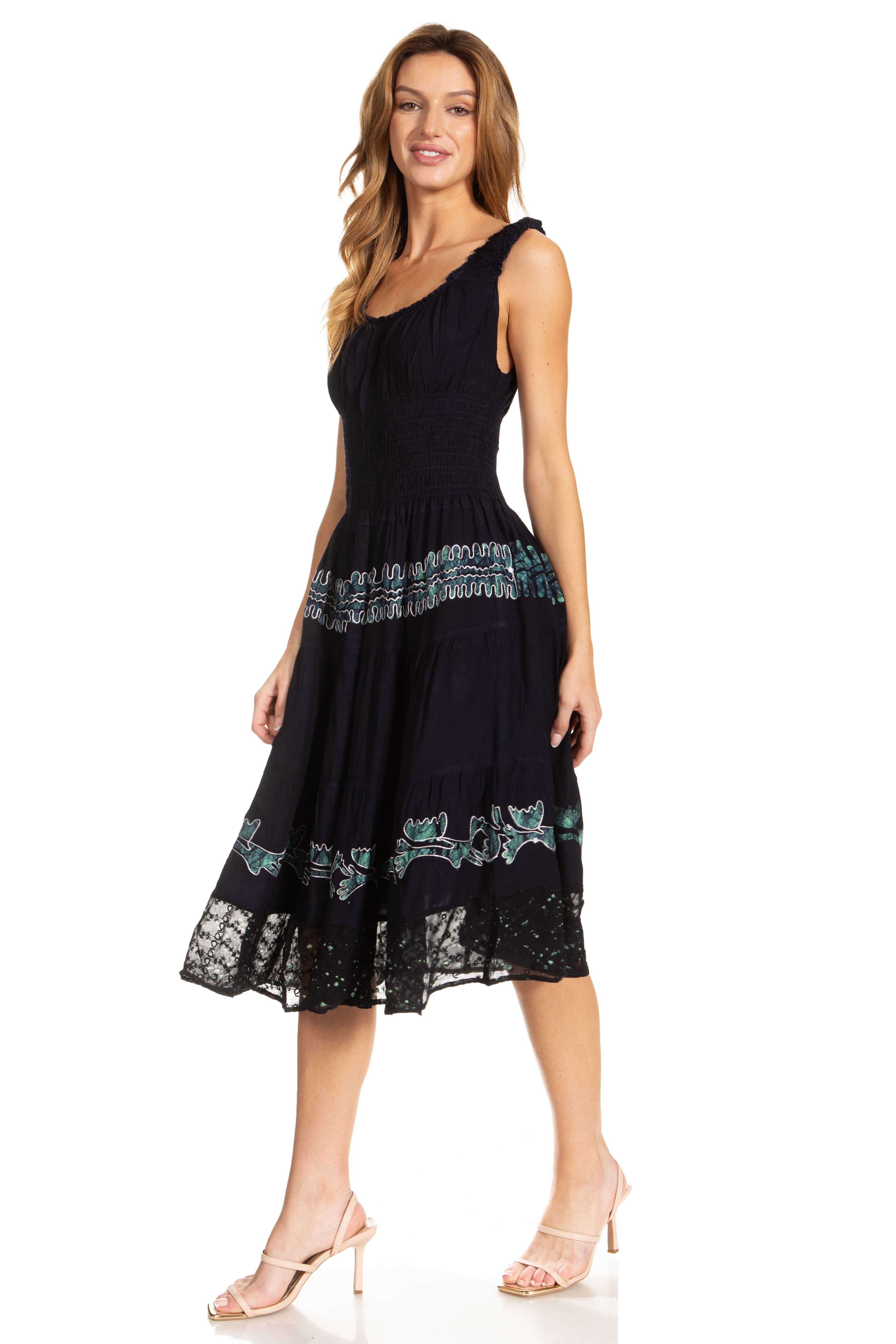 Woman wearing a black dress with green embroidery on a white background