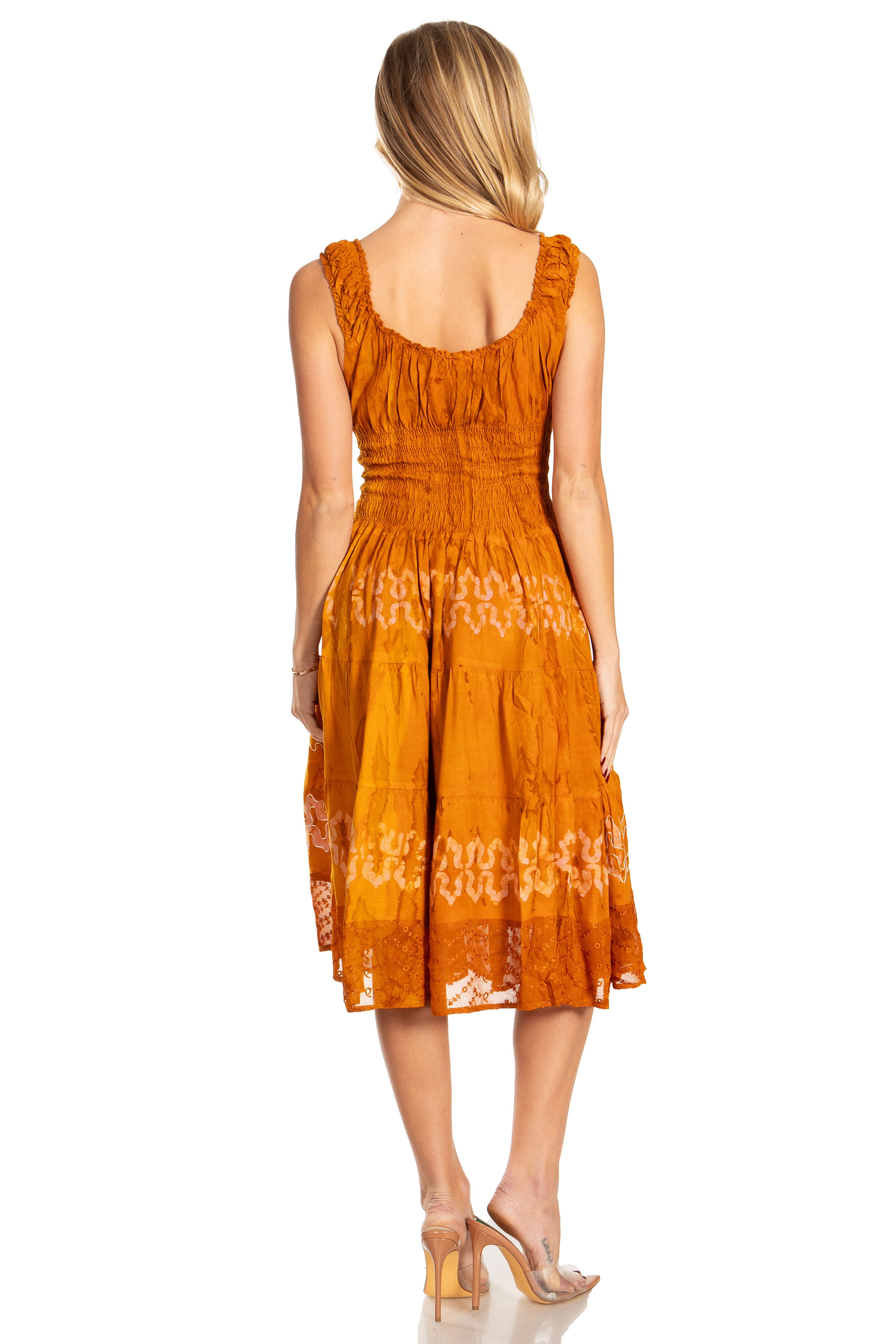 Woman wearing an orange dress with white patterns on a white background