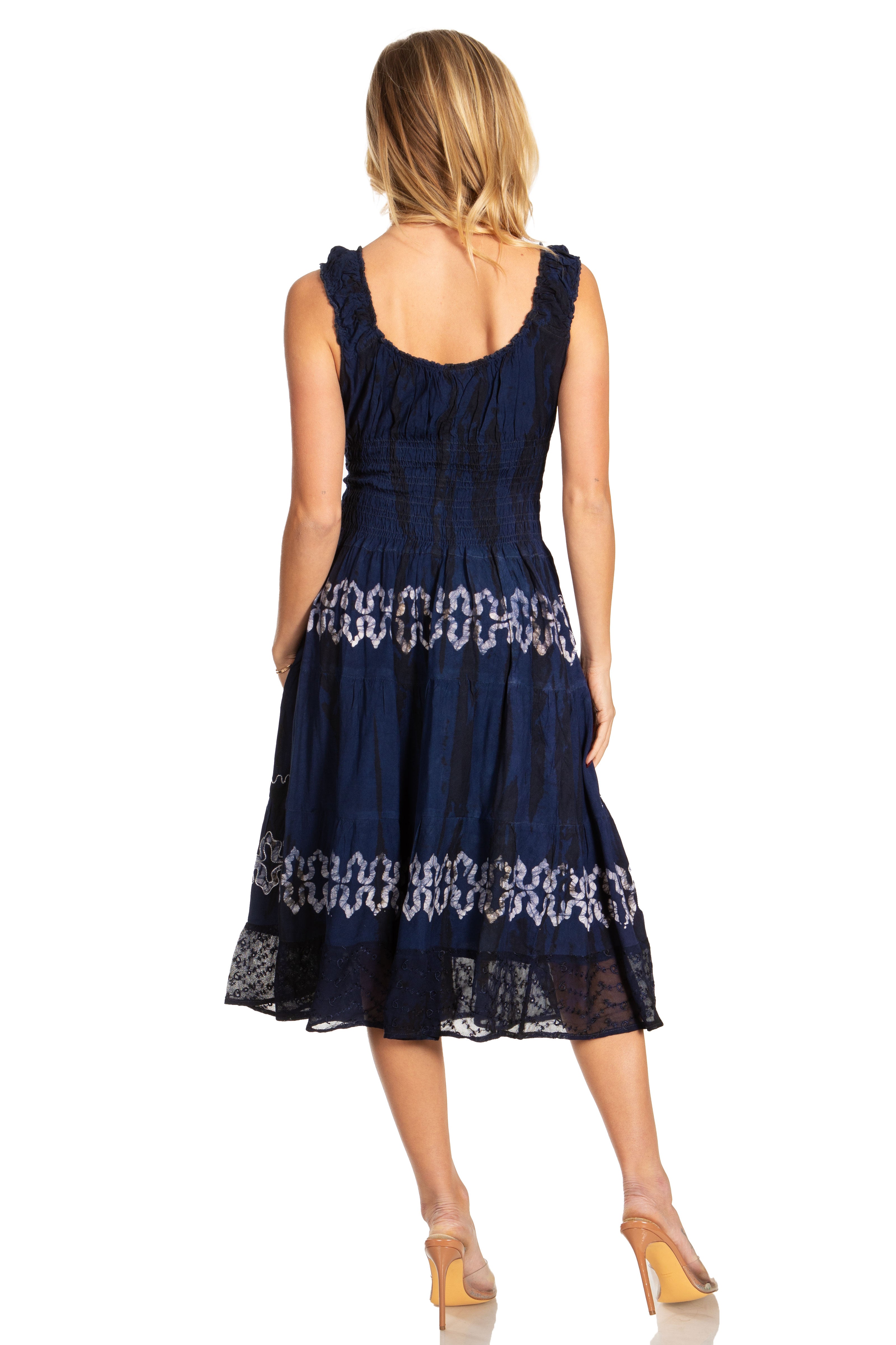 Woman wearing a navy blue dress with white lace details on a white background