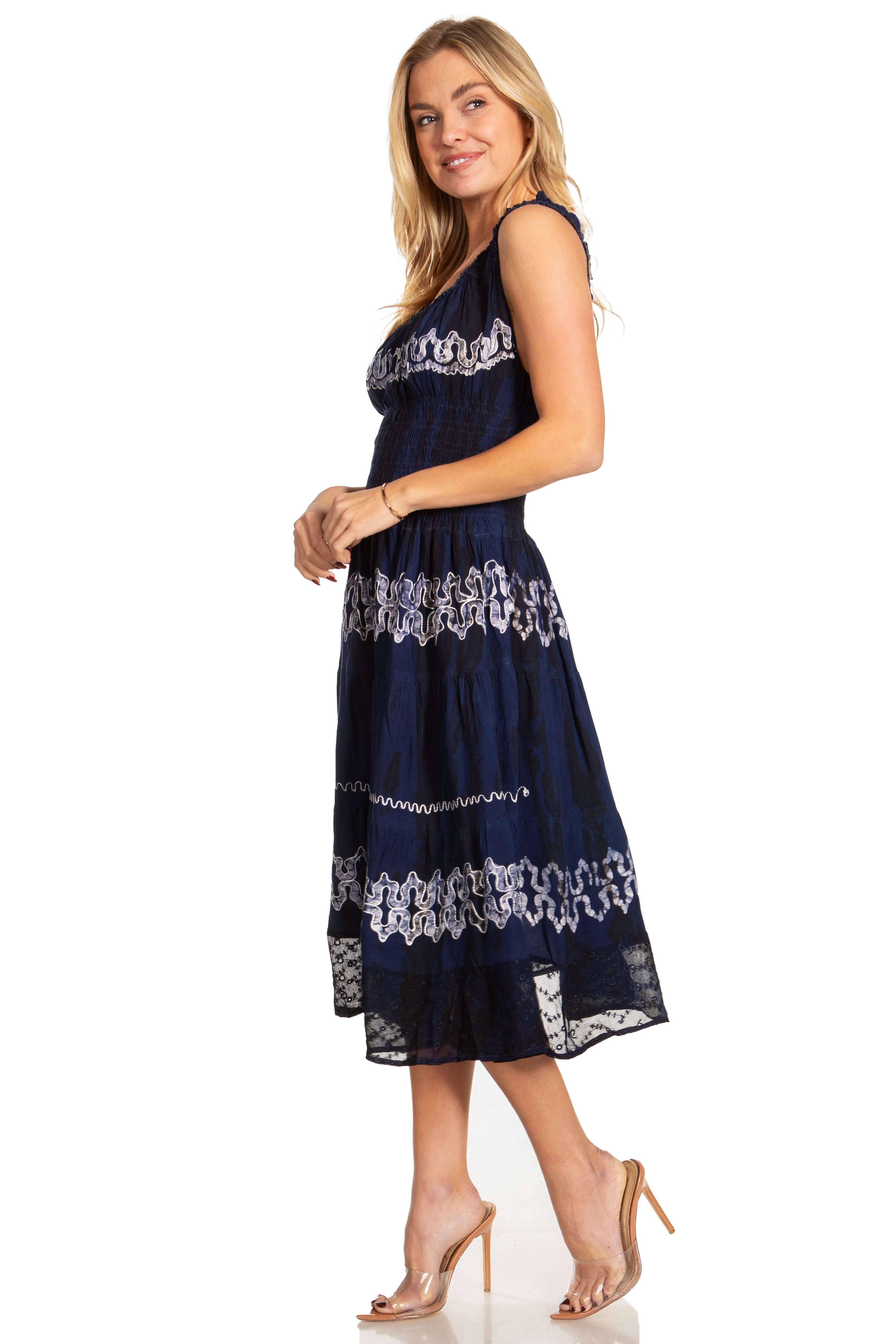 Woman wearing a navy blue dress with white lace details on a white background