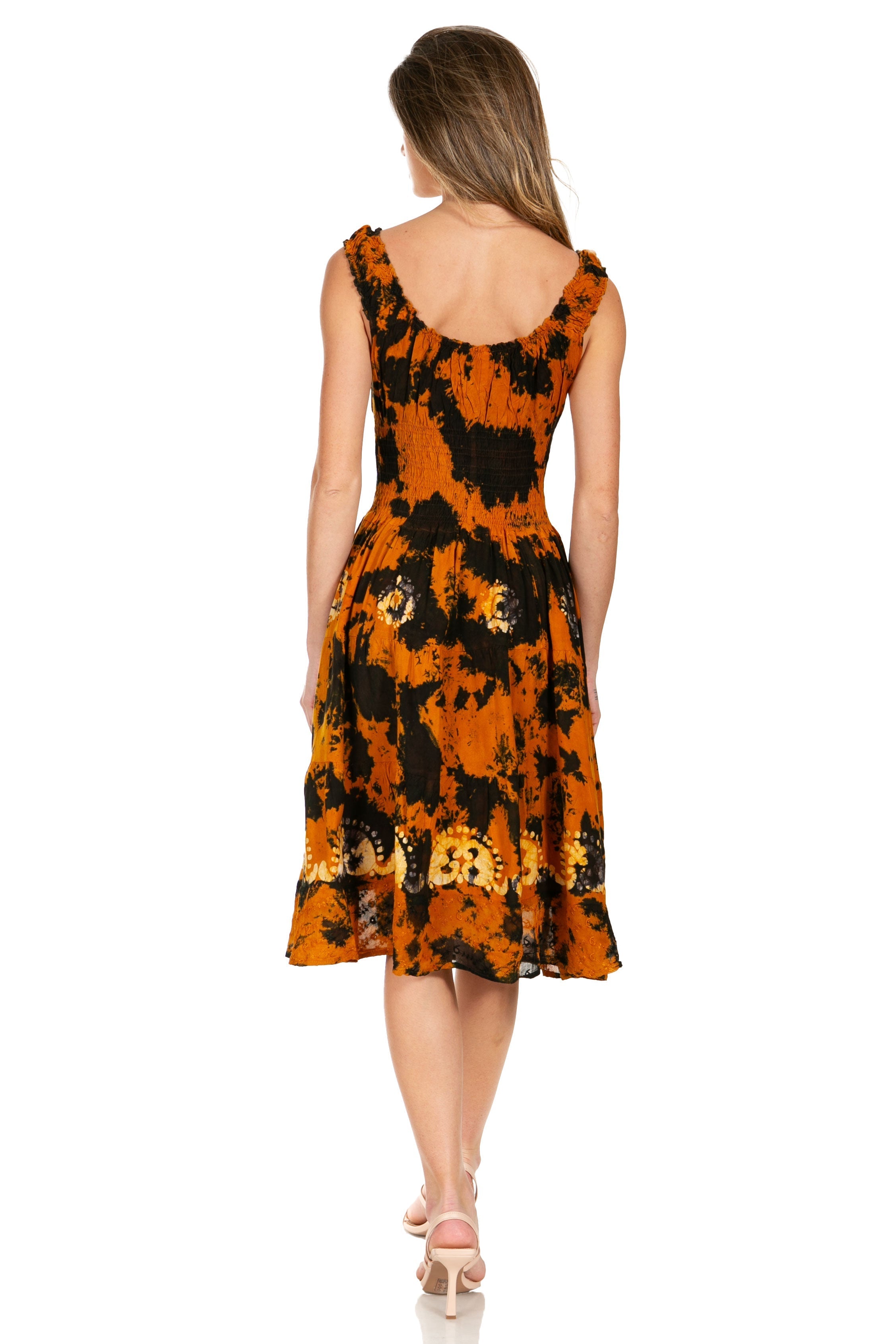 Woman wearing a tie-dye dress with orange and black pattern on a white background