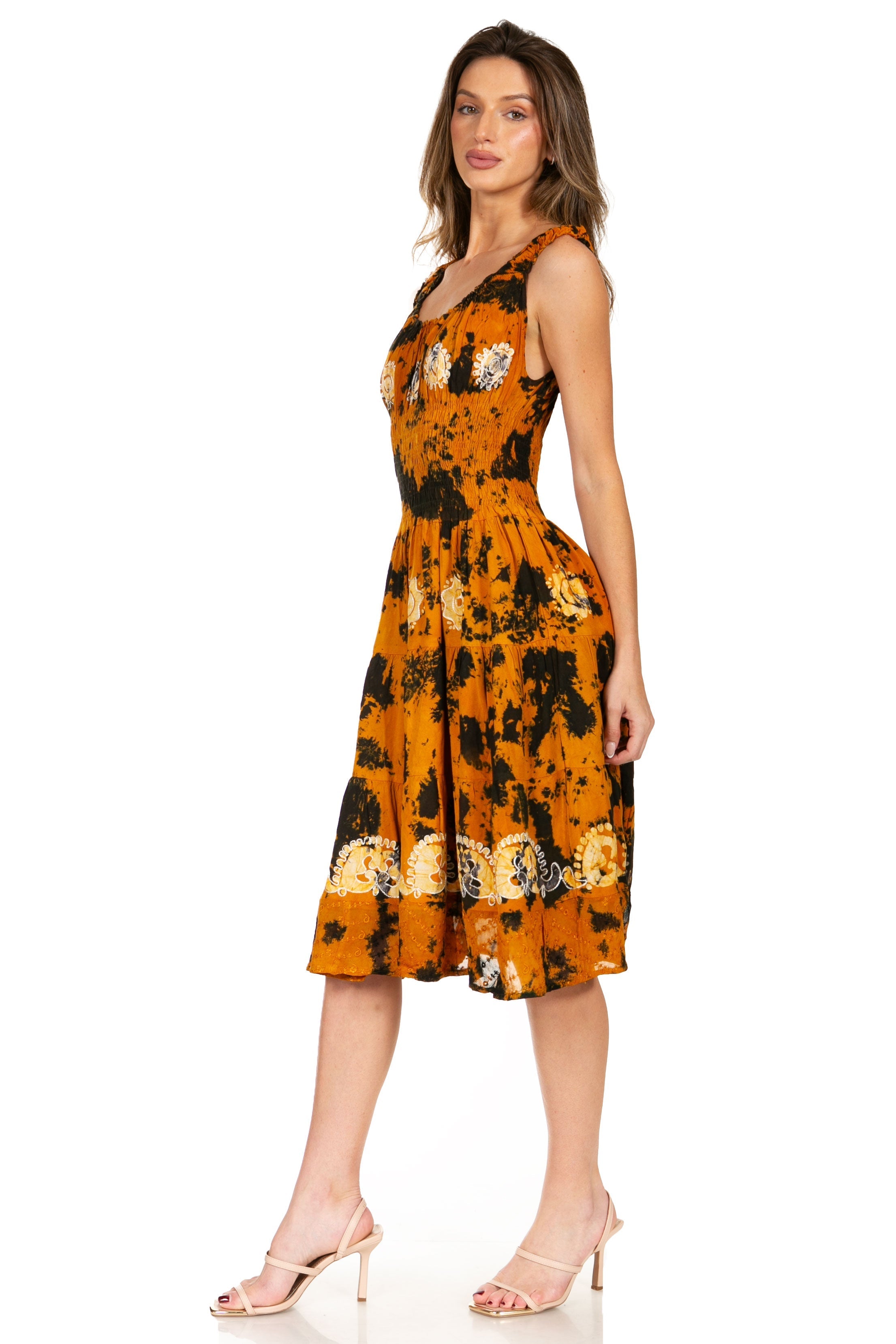Woman wearing a tie-dye dress with orange and black pattern on a white background