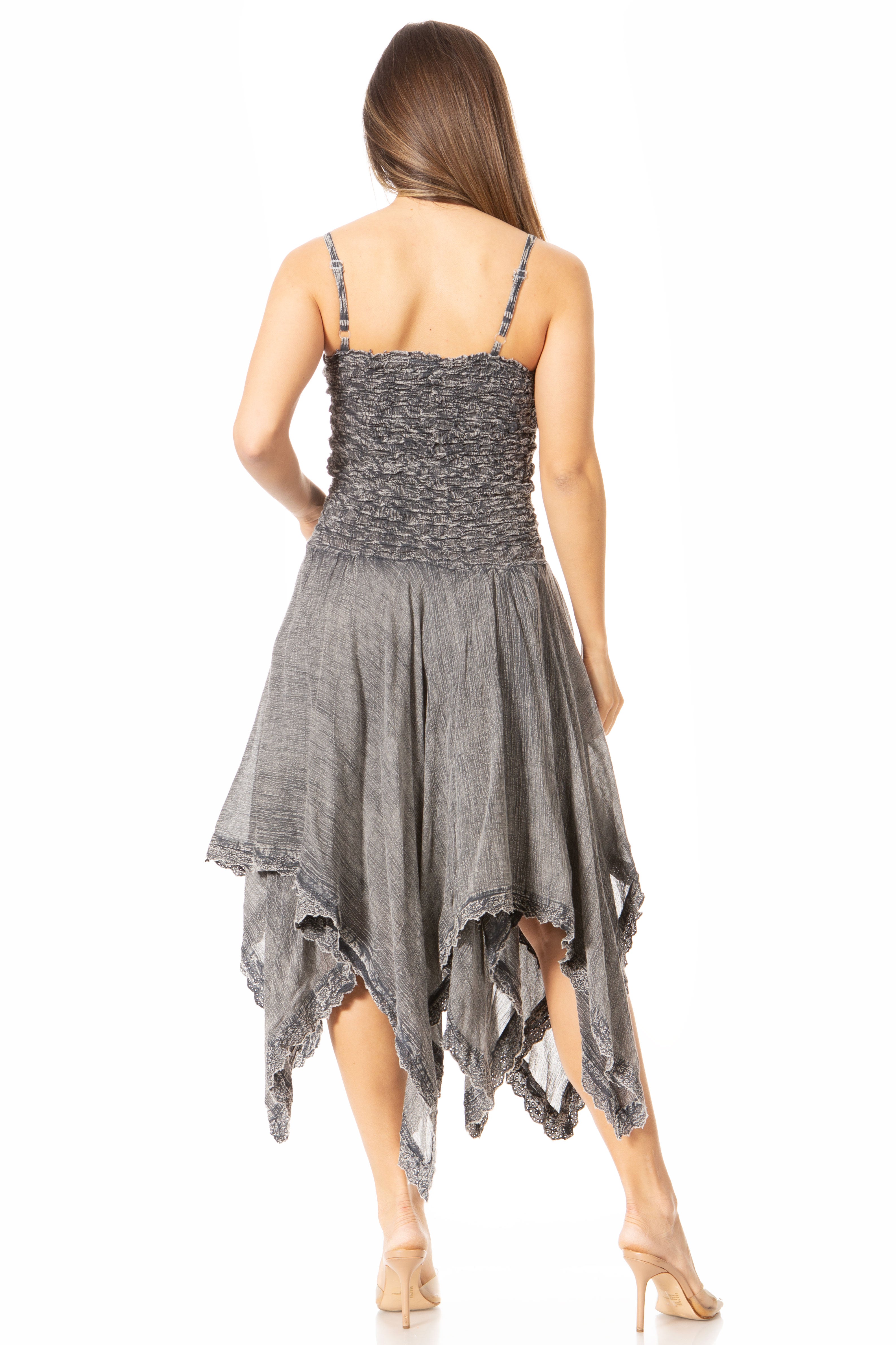 Woman wearing a gray dress with an asymmetrical hem on a white background