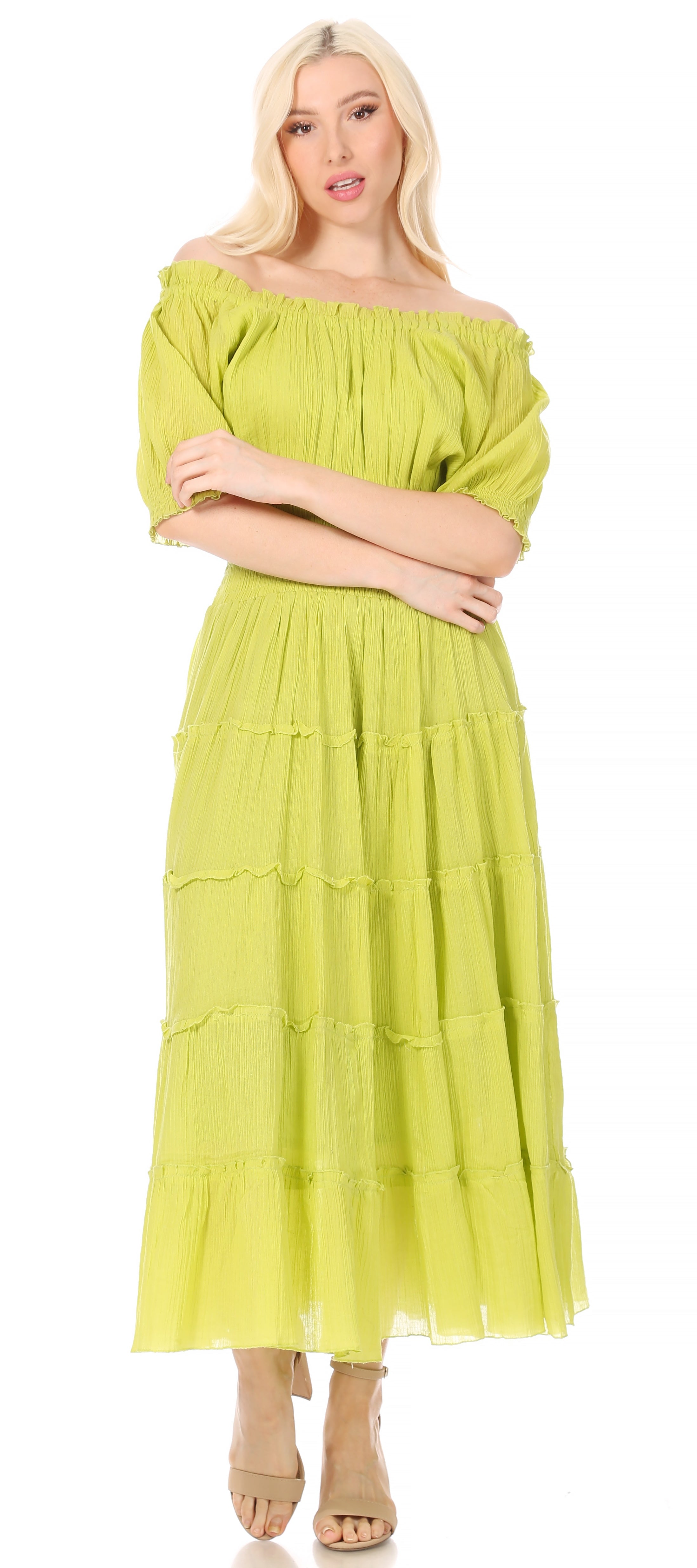 Woman wearing a light green off-shoulder dress on a white background