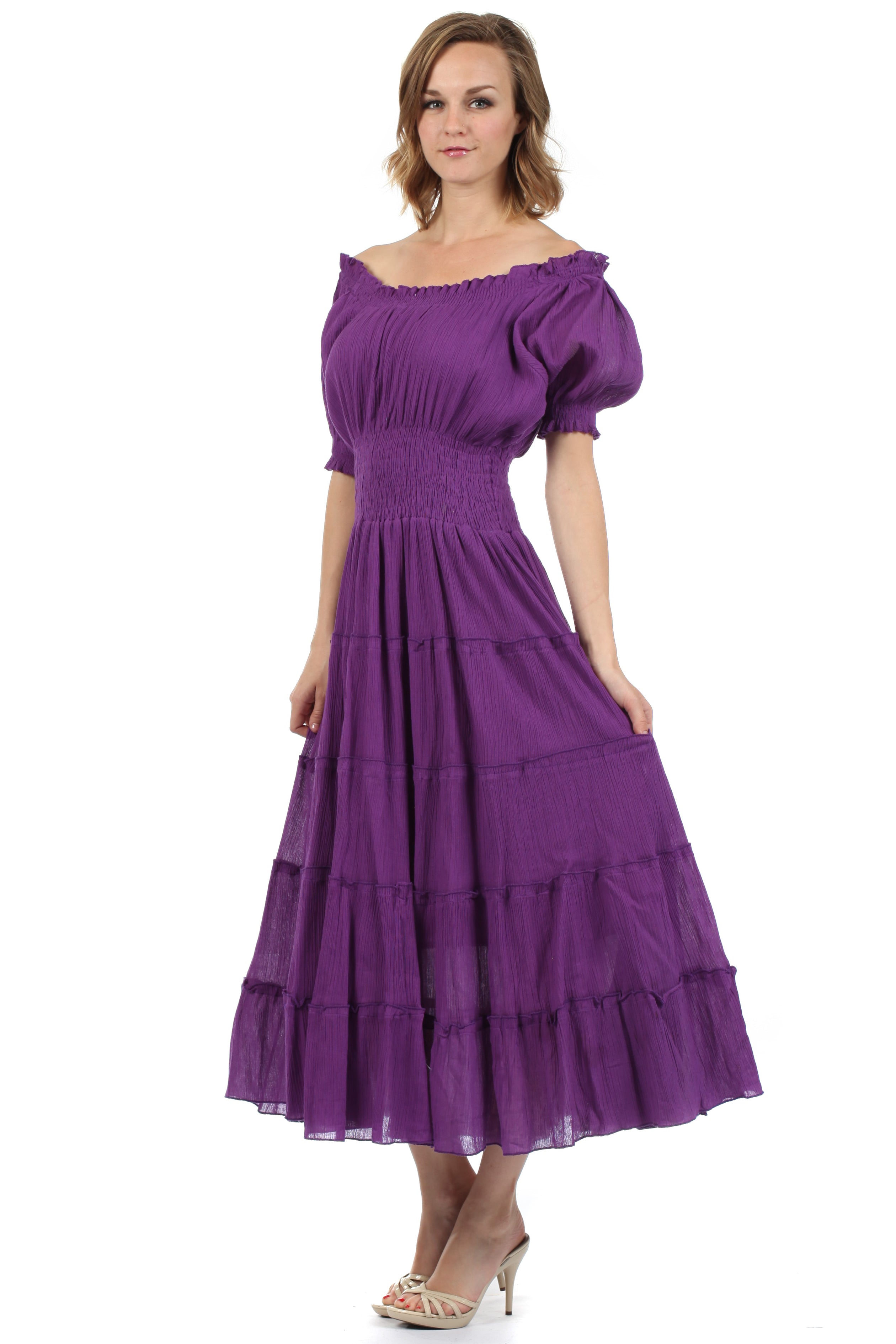 Woman wearing a purple dress with puffed sleeves and tiered skirt on a white background
