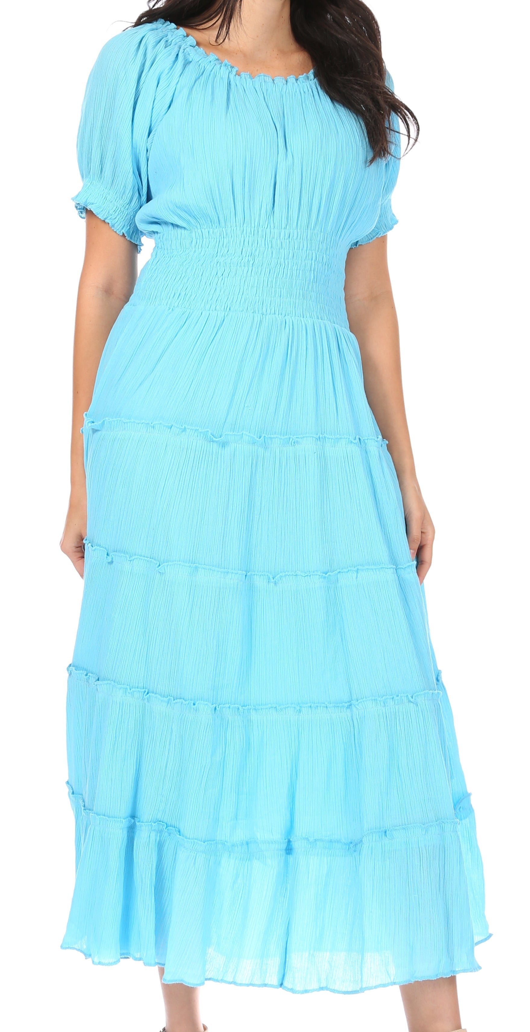 Woman wearing a light blue dress with ruffled layers on a white background