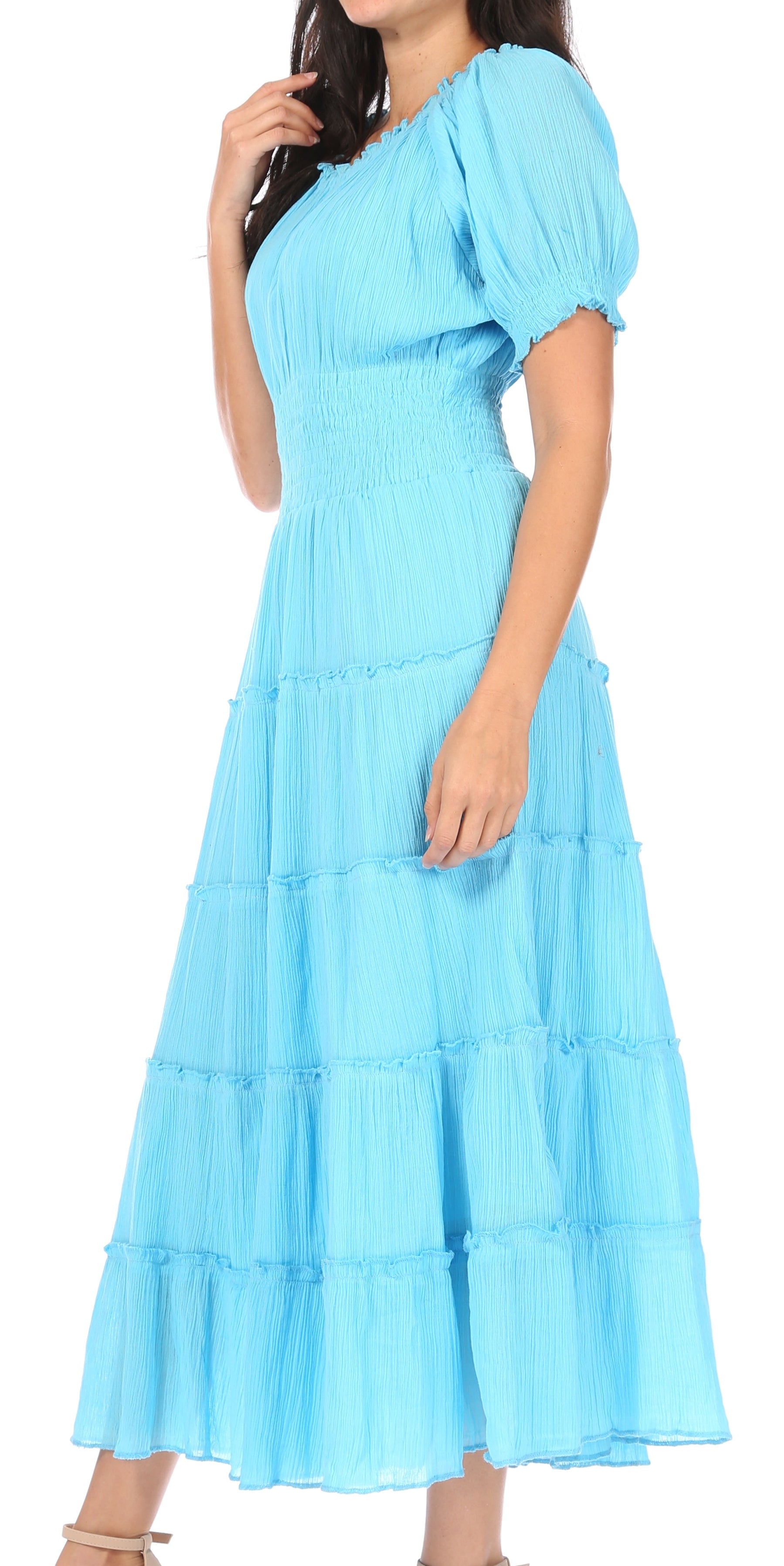 Woman wearing a light blue dress with ruffled sleeves and layers on a white background