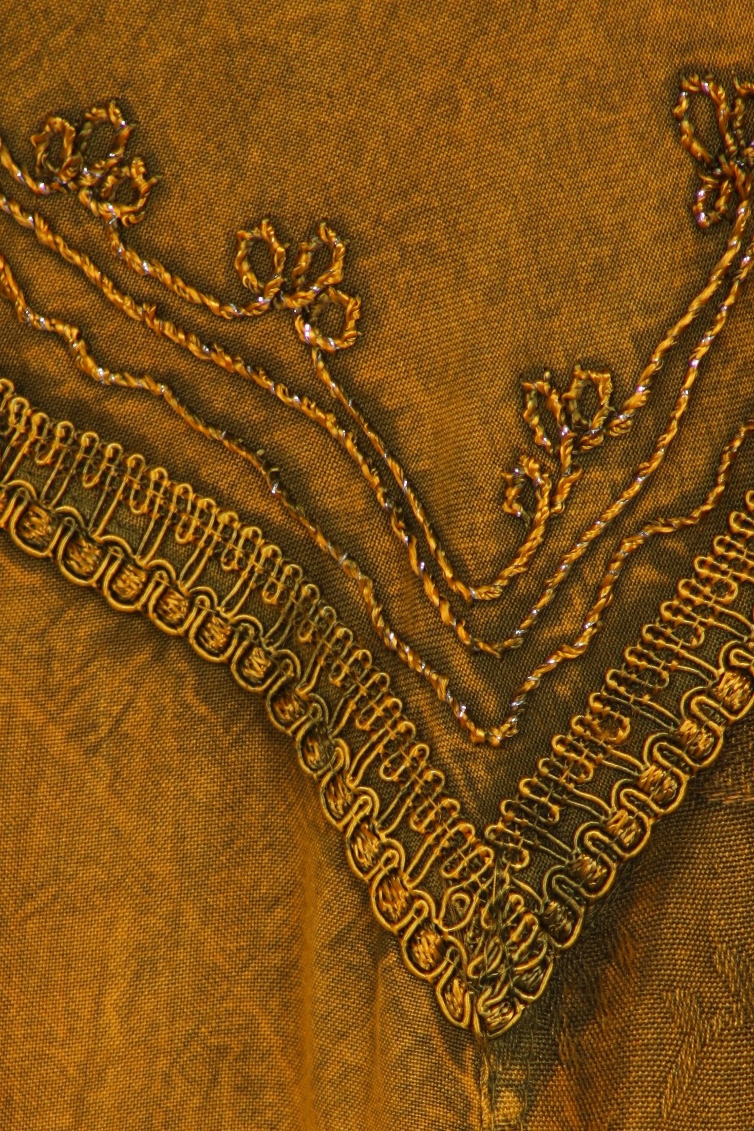 Close-up of embroidered fabric with floral patterns on a brown background