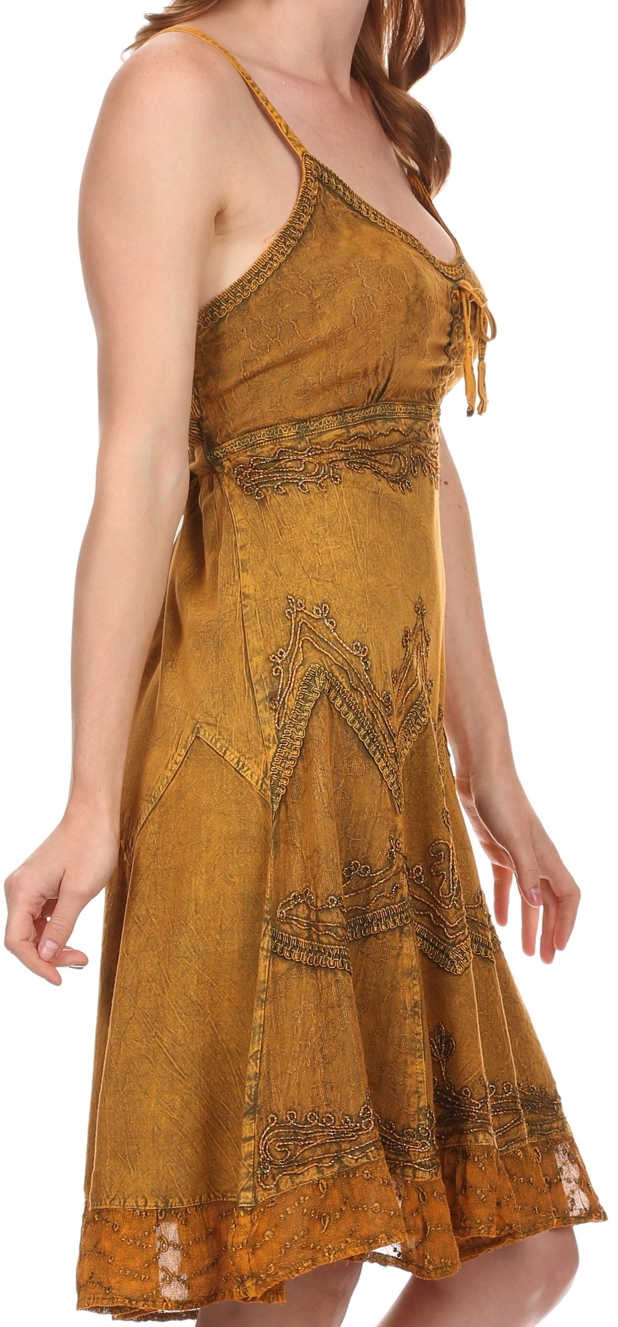 Woman wearing a mustard yellow dress with intricate patterns on a white background