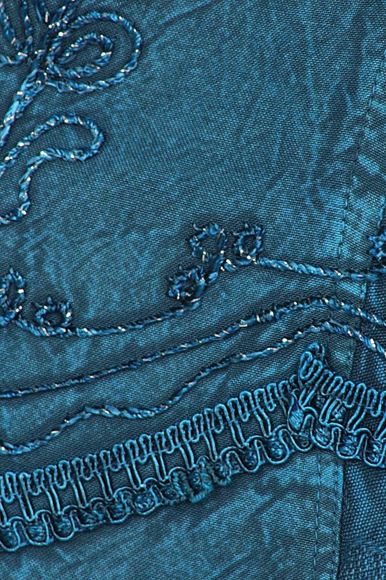 Close-up of blue fabric with intricate patterns and stitching