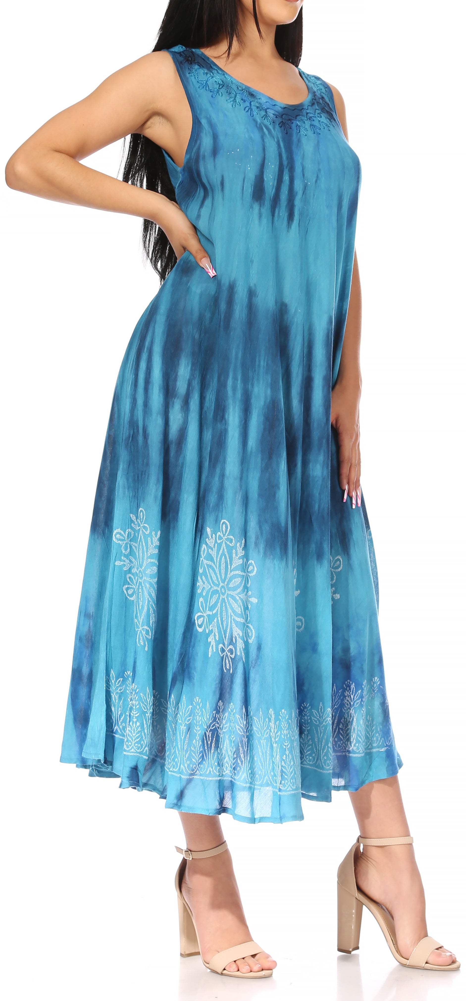 Woman wearing a blue tie-dye dress with floral embroidery on a white background