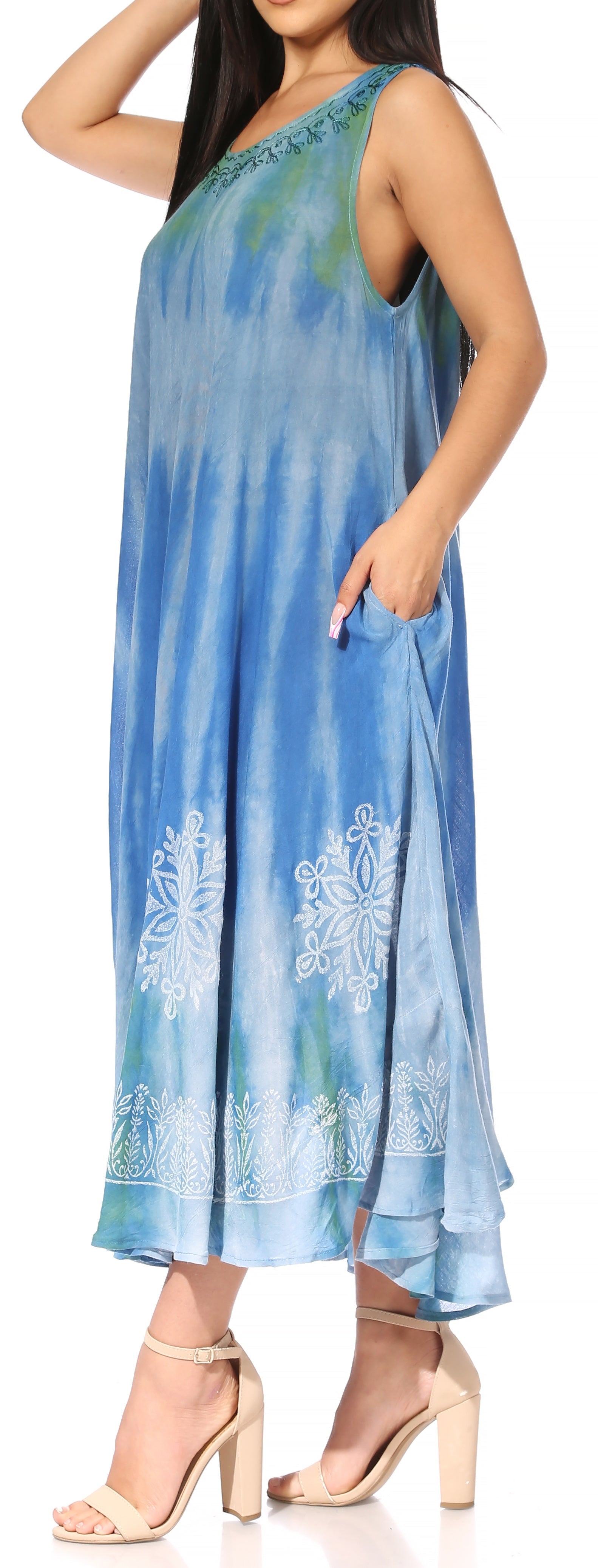 Woman wearing a blue tie-dye dress with floral patterns on a white background
