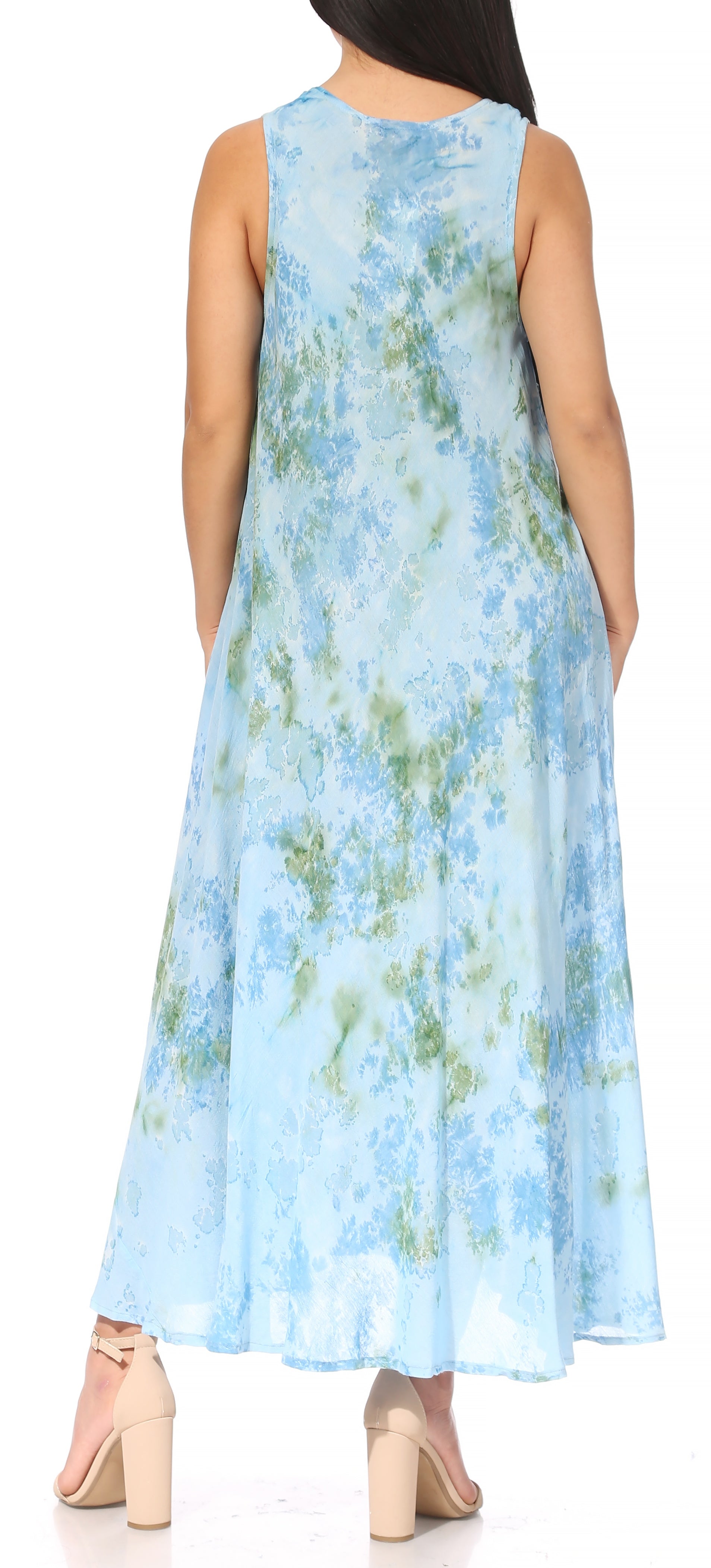 Woman wearing a sleeveless floral dress with a blue and green pattern.