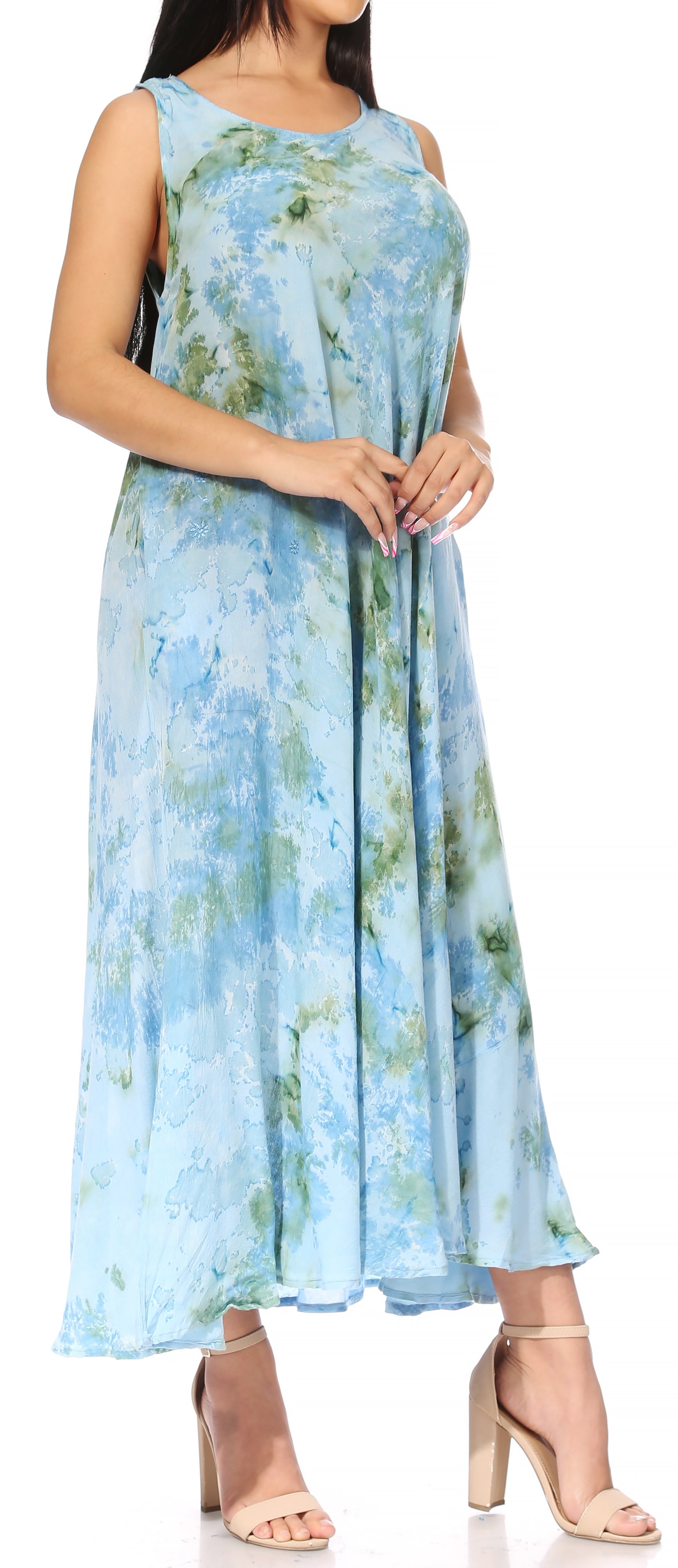 Woman wearing a sleeveless floral dress with a blue and green pattern on a white background