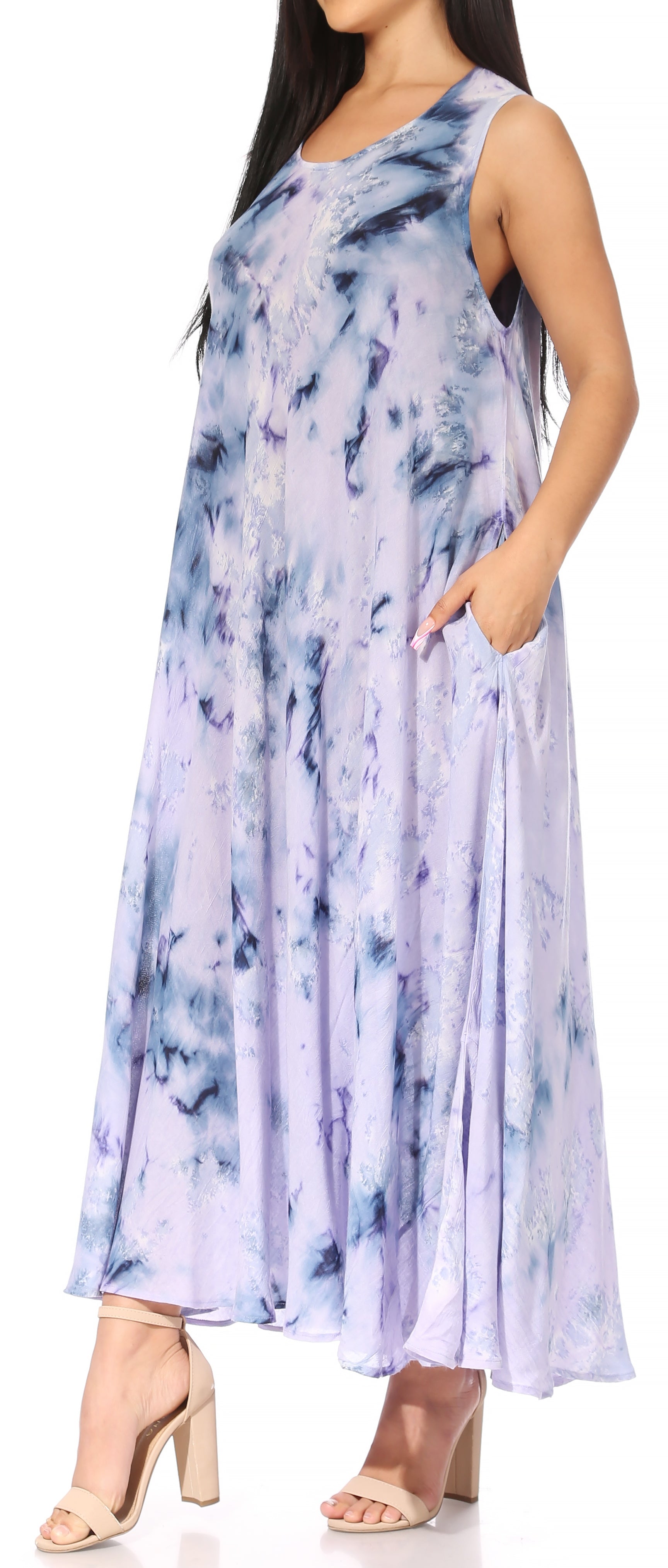 Woman wearing a sleeveless, tie-dye dress with a white background