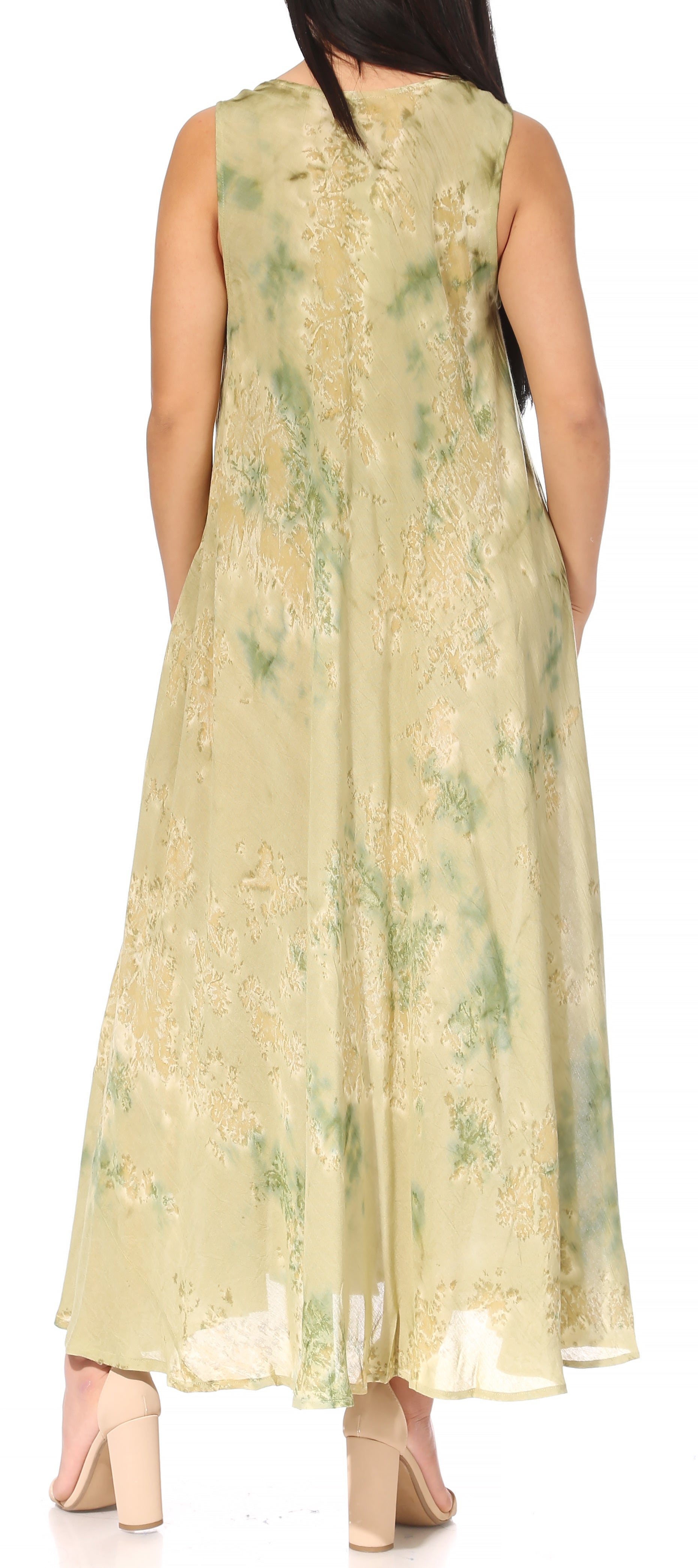 Woman wearing a long, light-colored dress with floral patterns on a white background