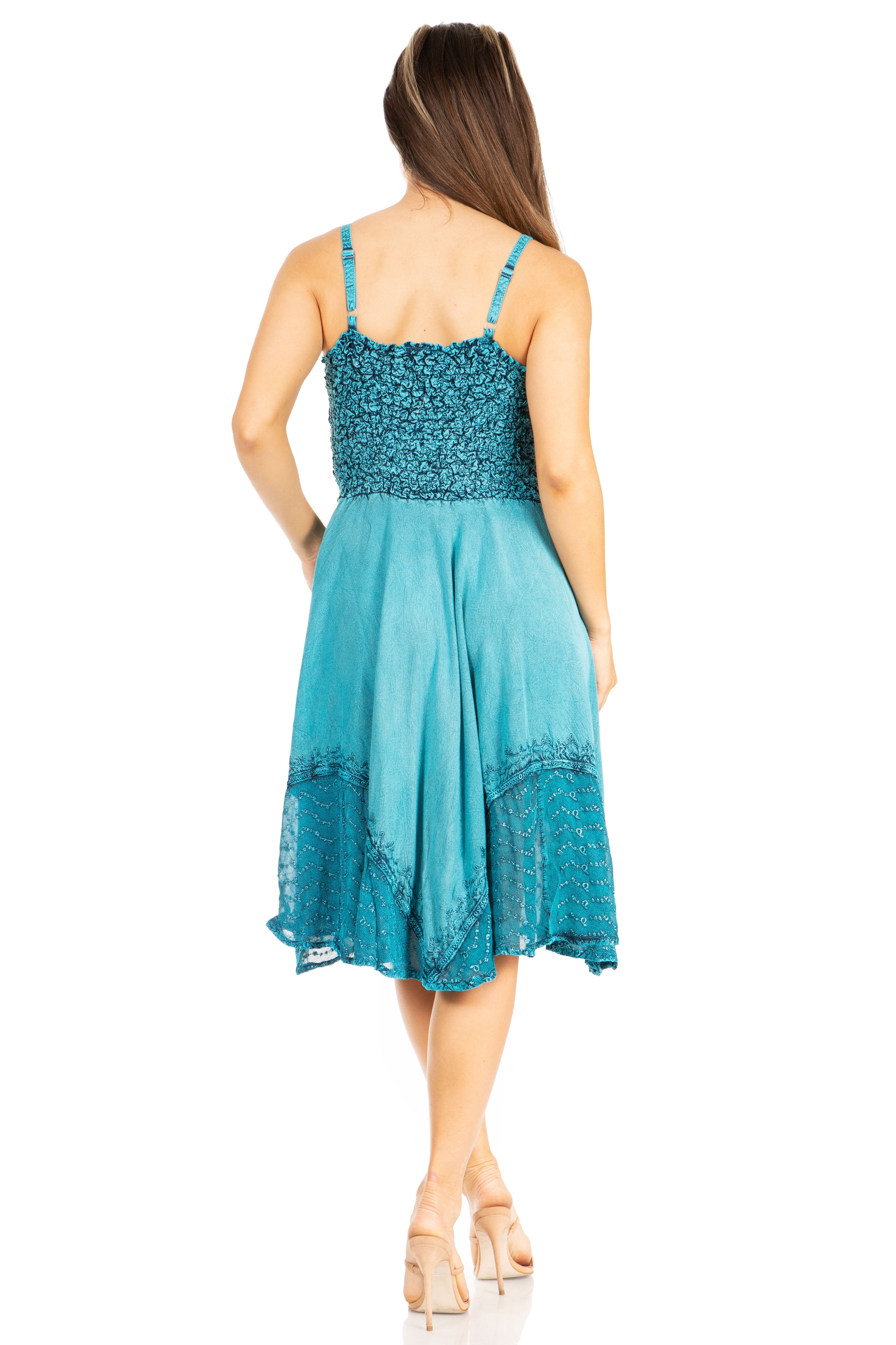 Woman wearing a teal dress with lace details on a white background
