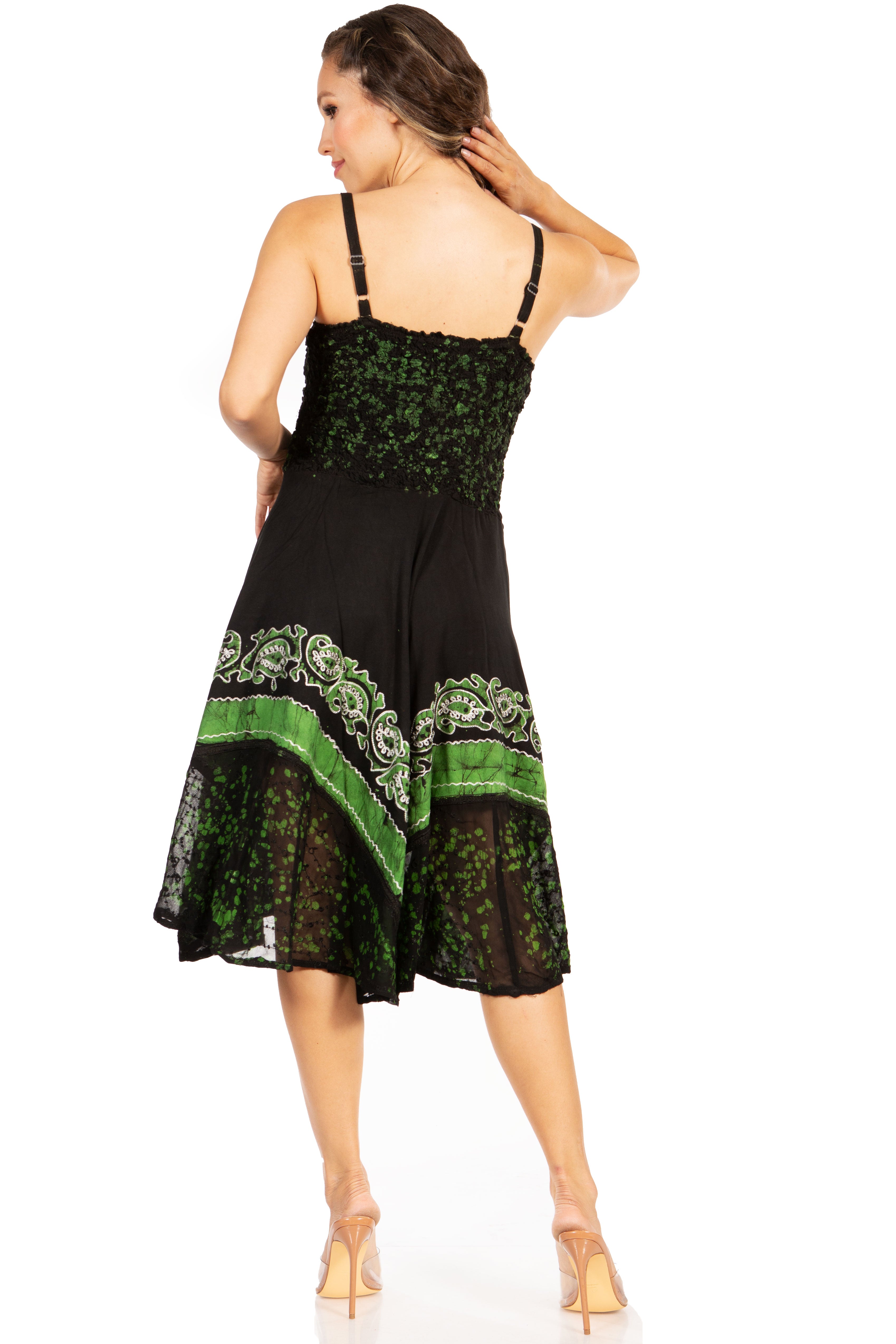 Woman wearing a black dress with green floral patterns on a white background