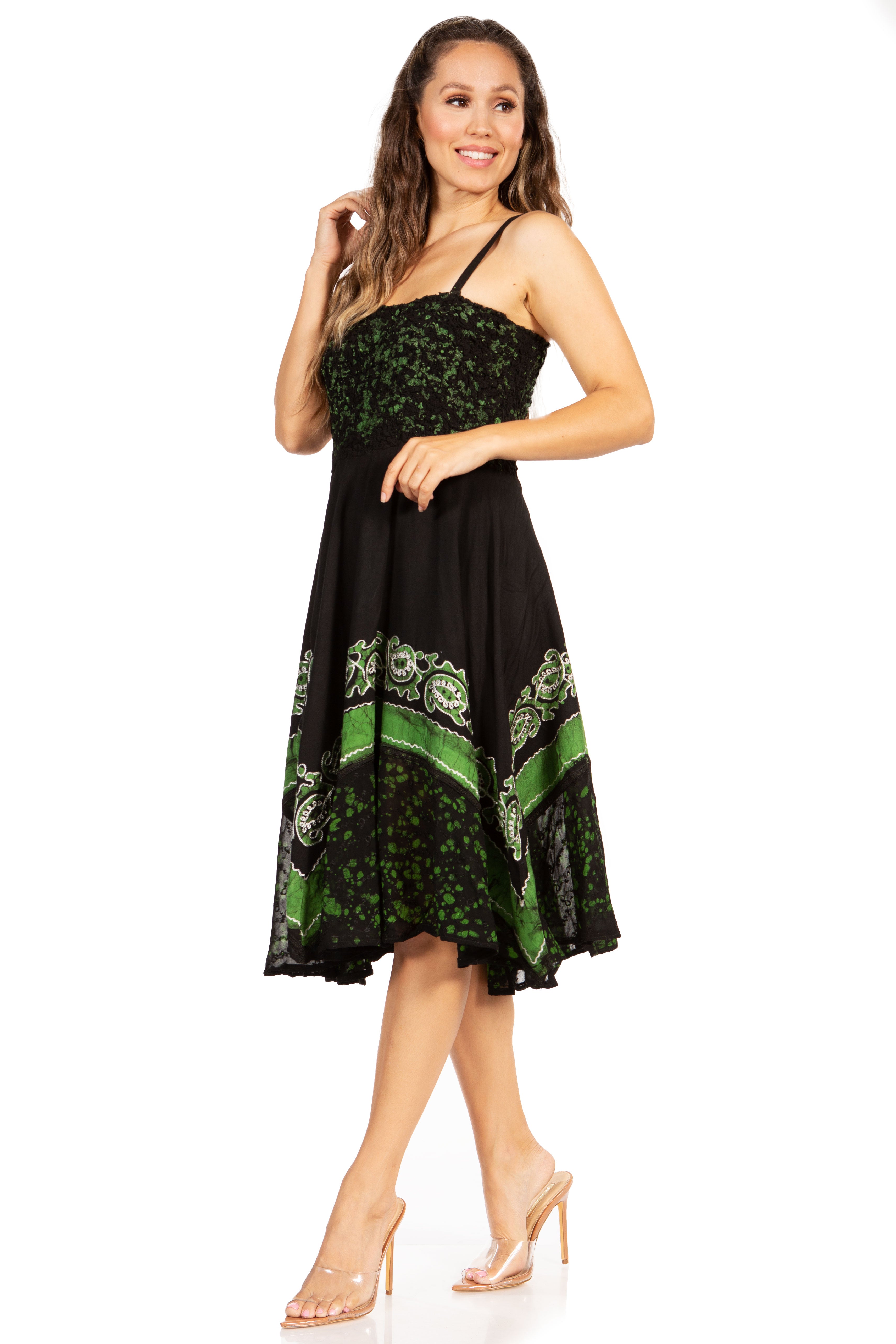 Woman wearing a black dress with green floral patterns on a white background