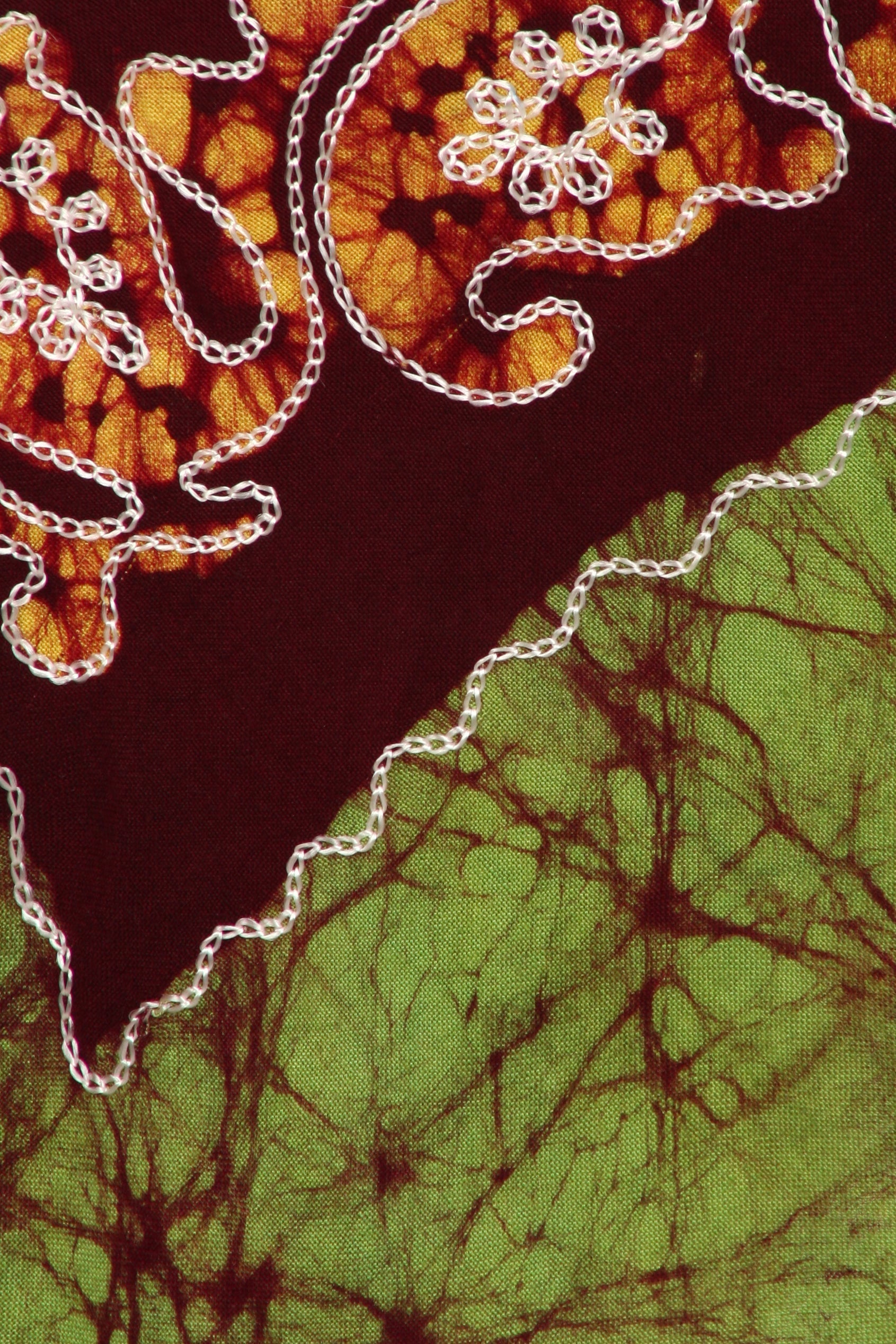 Textile with batik pattern featuring brown, green, and white.