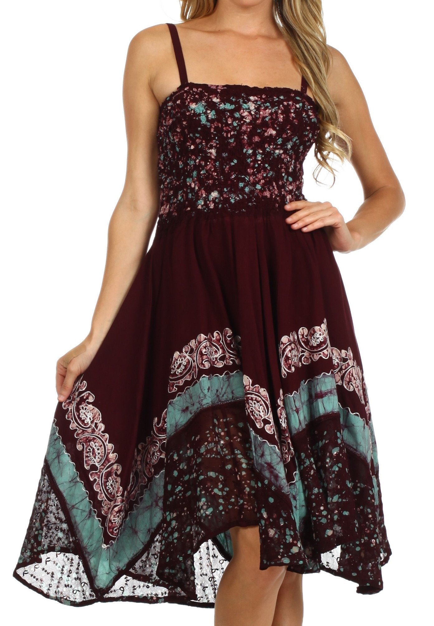 Woman wearing a patterned dress with maroon, turquoise, and floral design on a white background