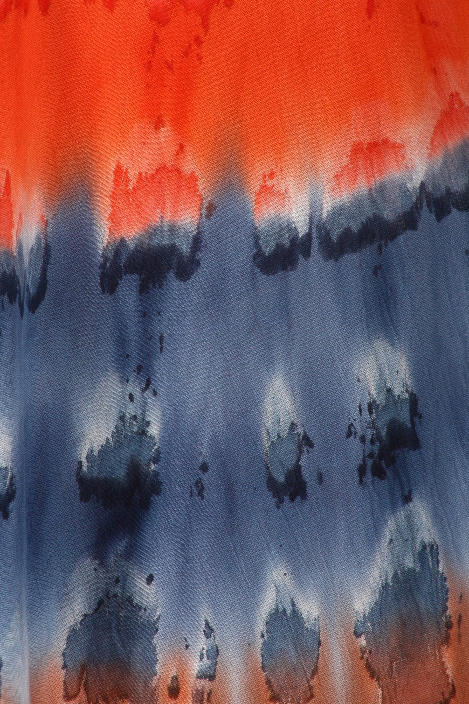 Abstract tie-dye pattern with orange, blue, and black colors.