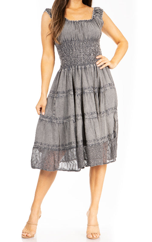 Woman wearing a gray dress with smocked bodice and tiered skirt on a white background