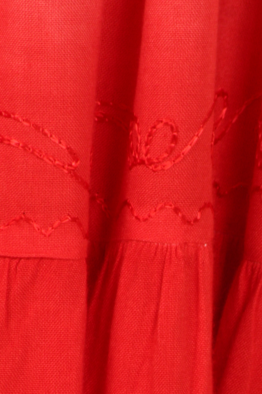 Close-up of a red fabric with intricate stitching details