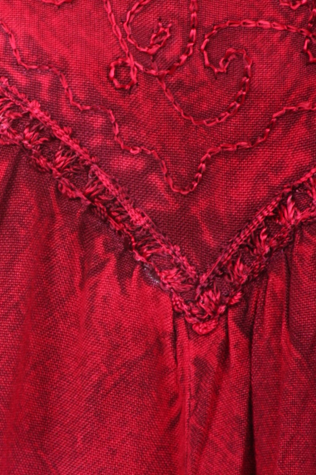 Close-up of red fabric with intricate stitching pattern