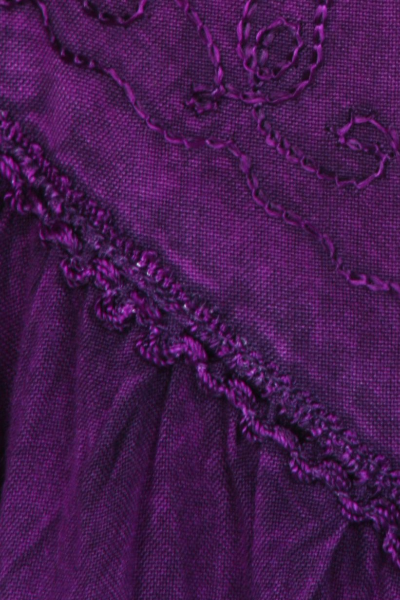 Close-up of a purple fabric with floral embroidery