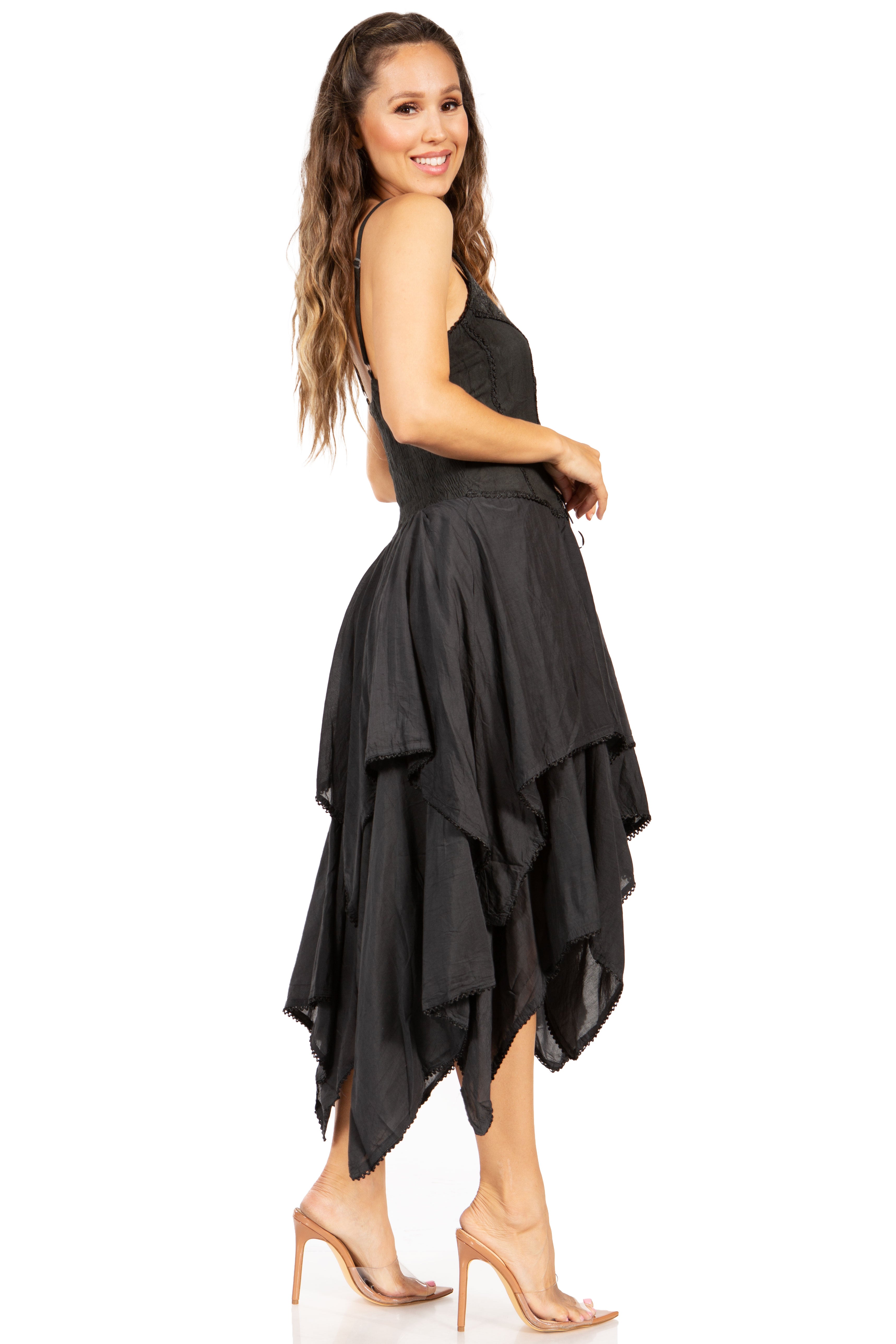 Woman wearing a black sleeveless dress with an asymmetrical hem on a white background