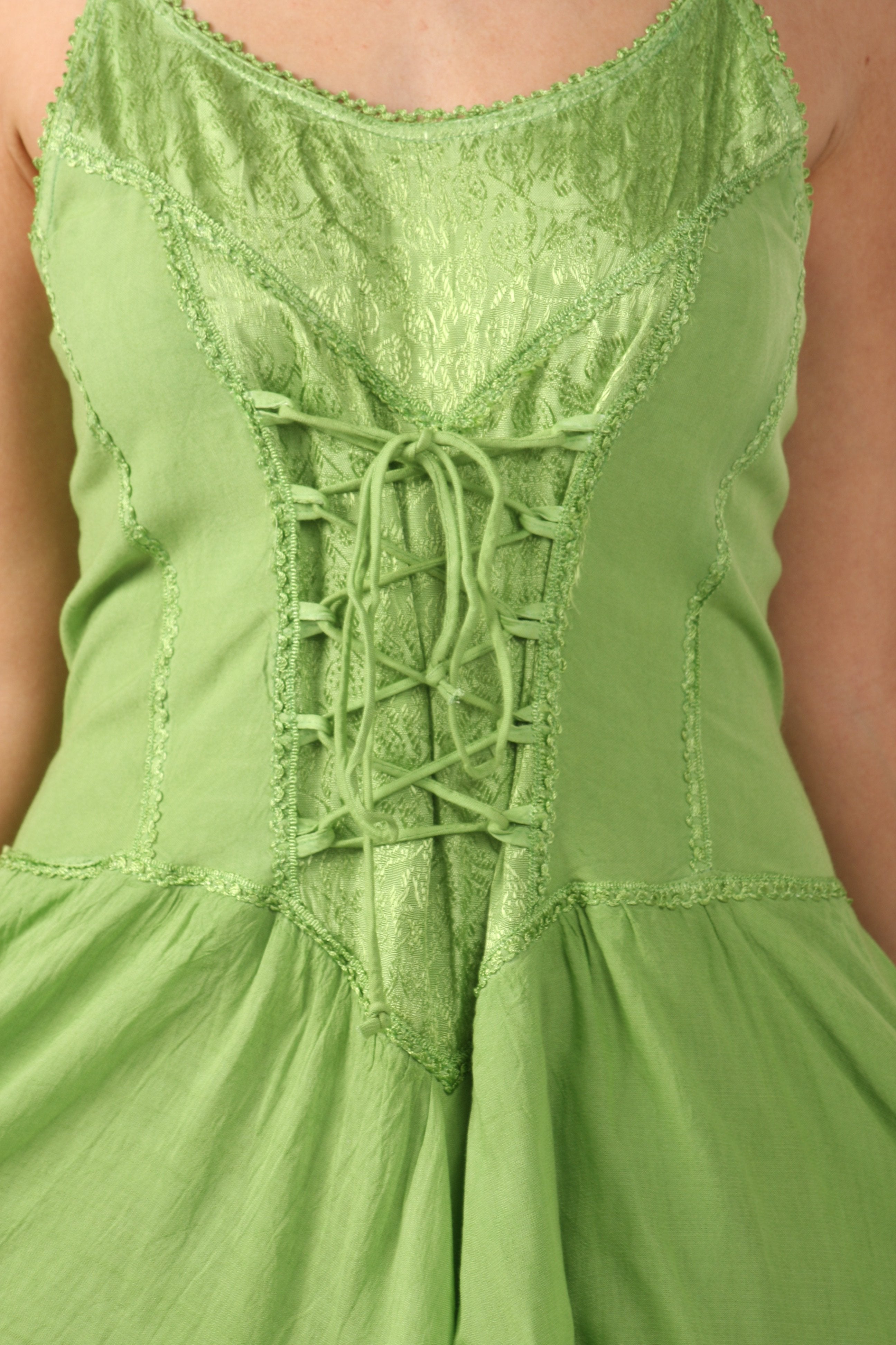 Green dress with lace-up front detail on a blurred background