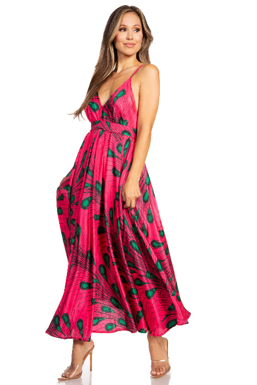 Woman wearing a pink dress with green patterns on a white background