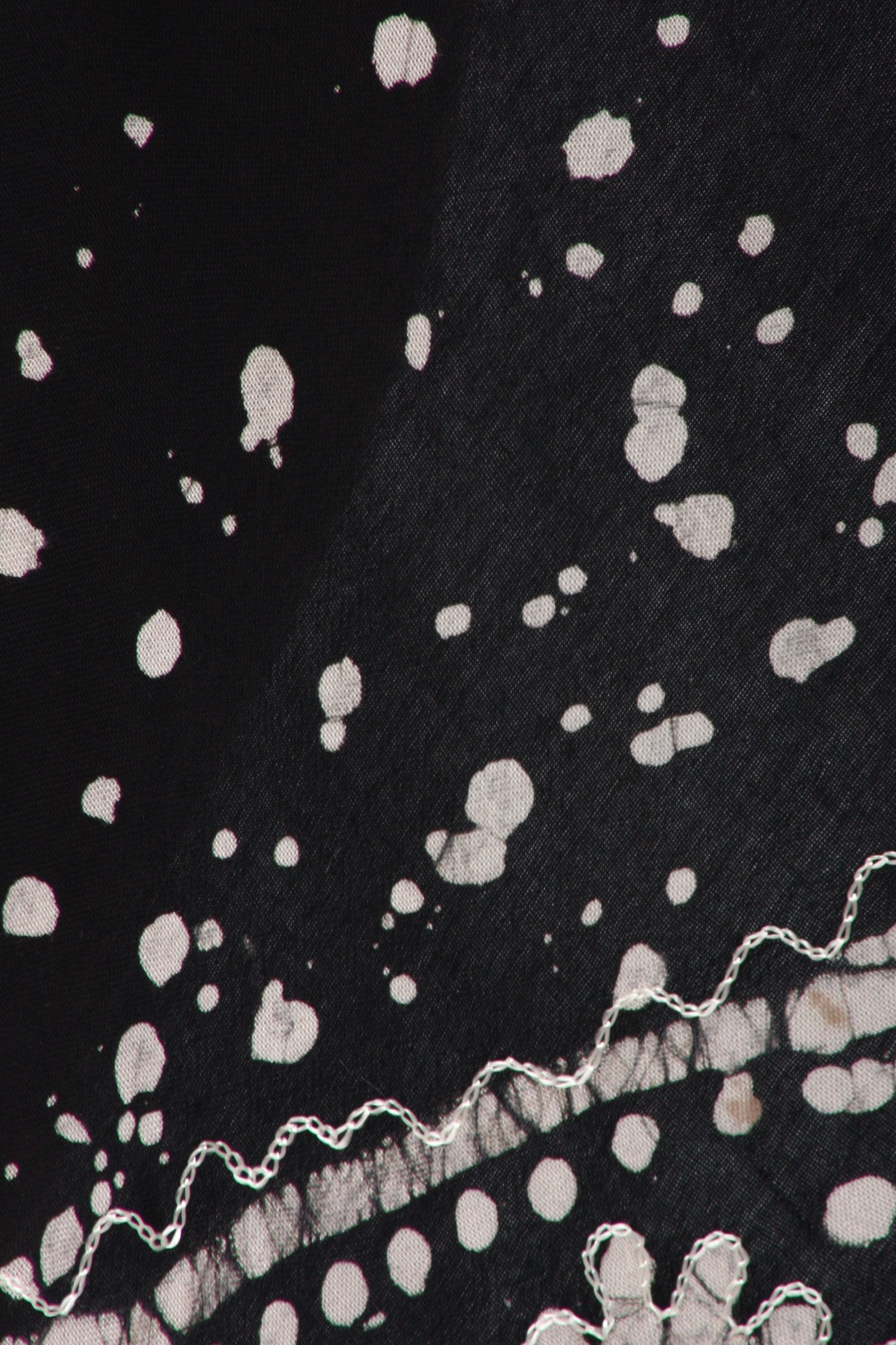 Black fabric with white polka dot pattern and lace trim