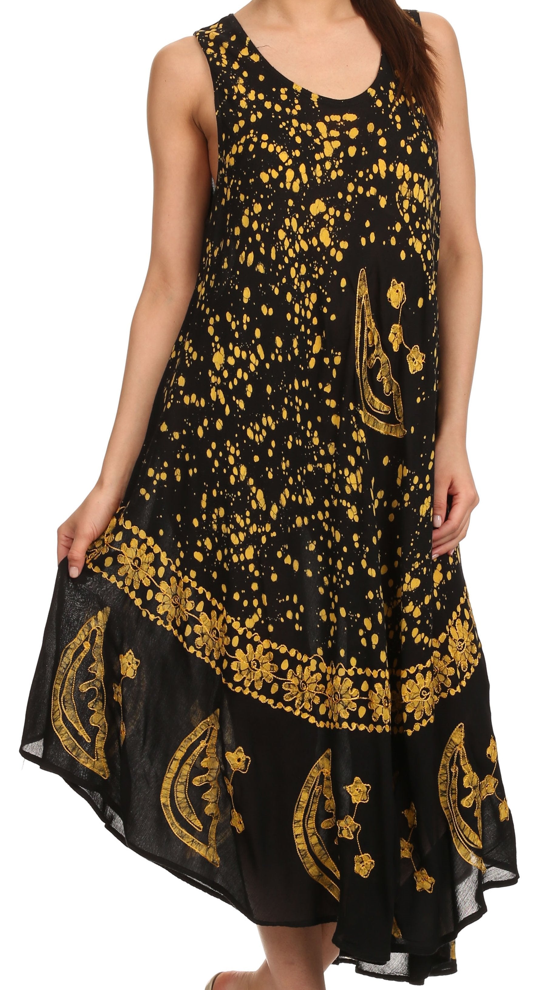Black dress with gold patterns worn by a model on a white background