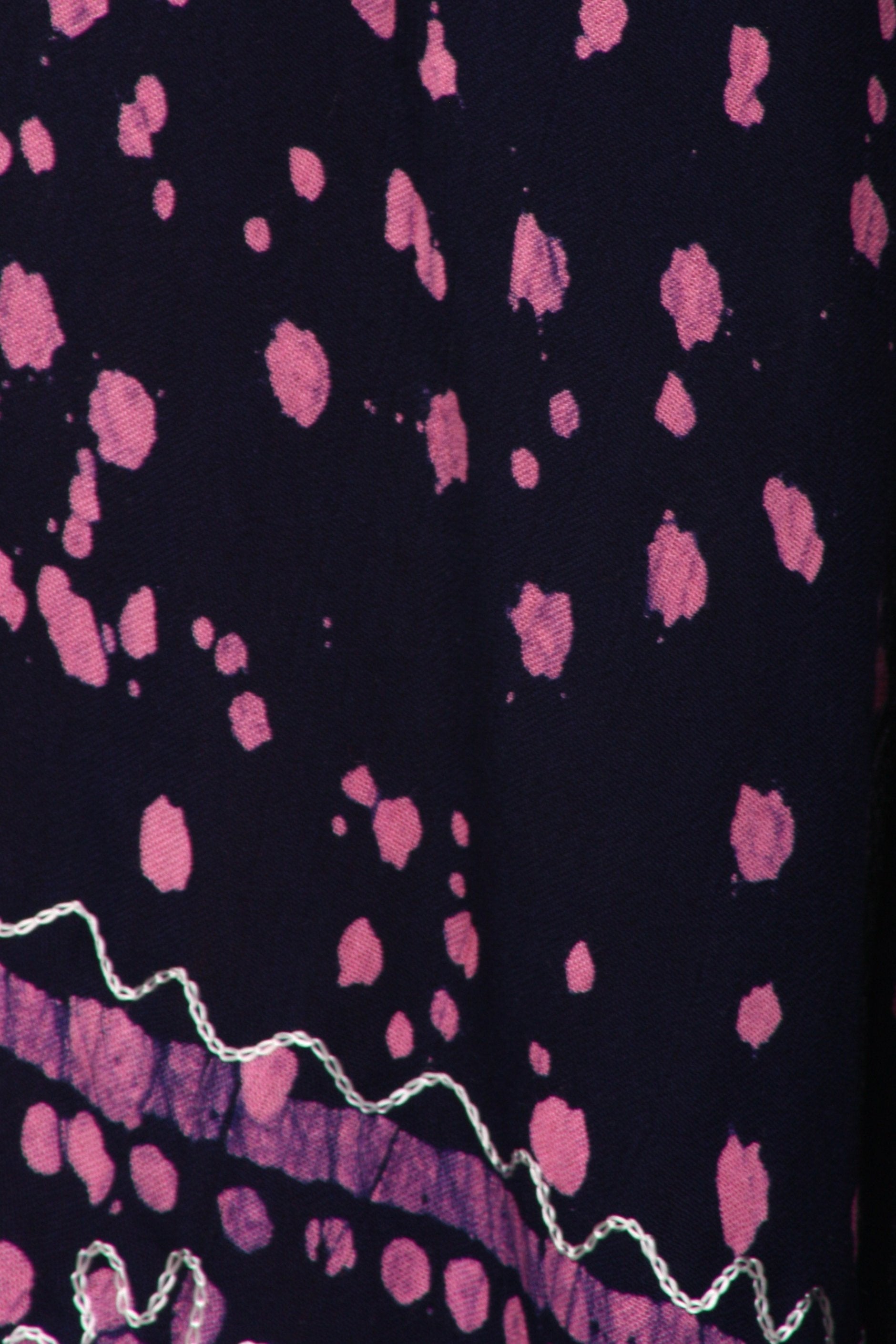 Close-up of a fabric with pink abstract patterns on a dark background