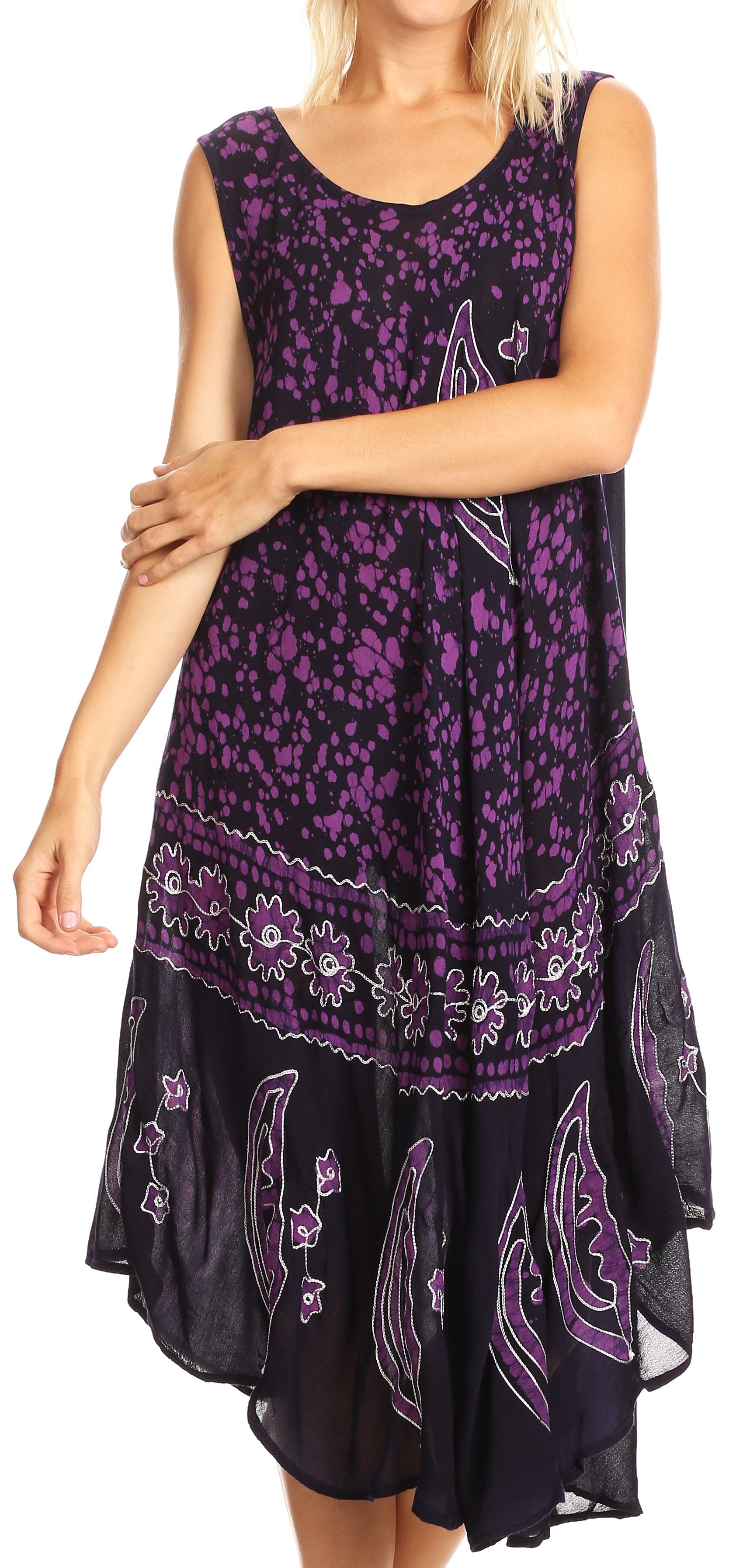 Woman wearing a sleeveless dress with purple floral and paisley patterns on a white background