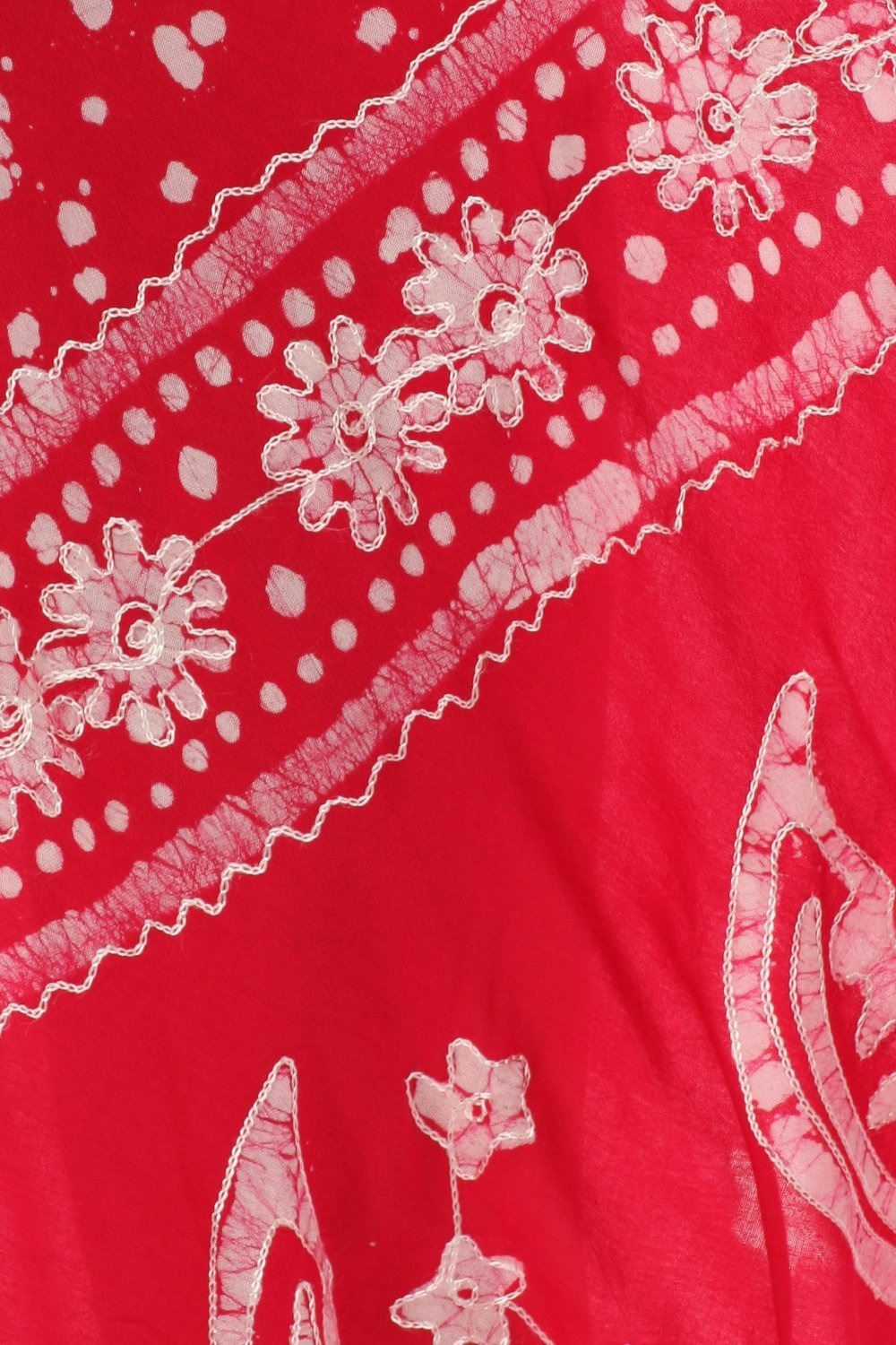 Close-up of a red fabric with white floral and polka dot patterns
